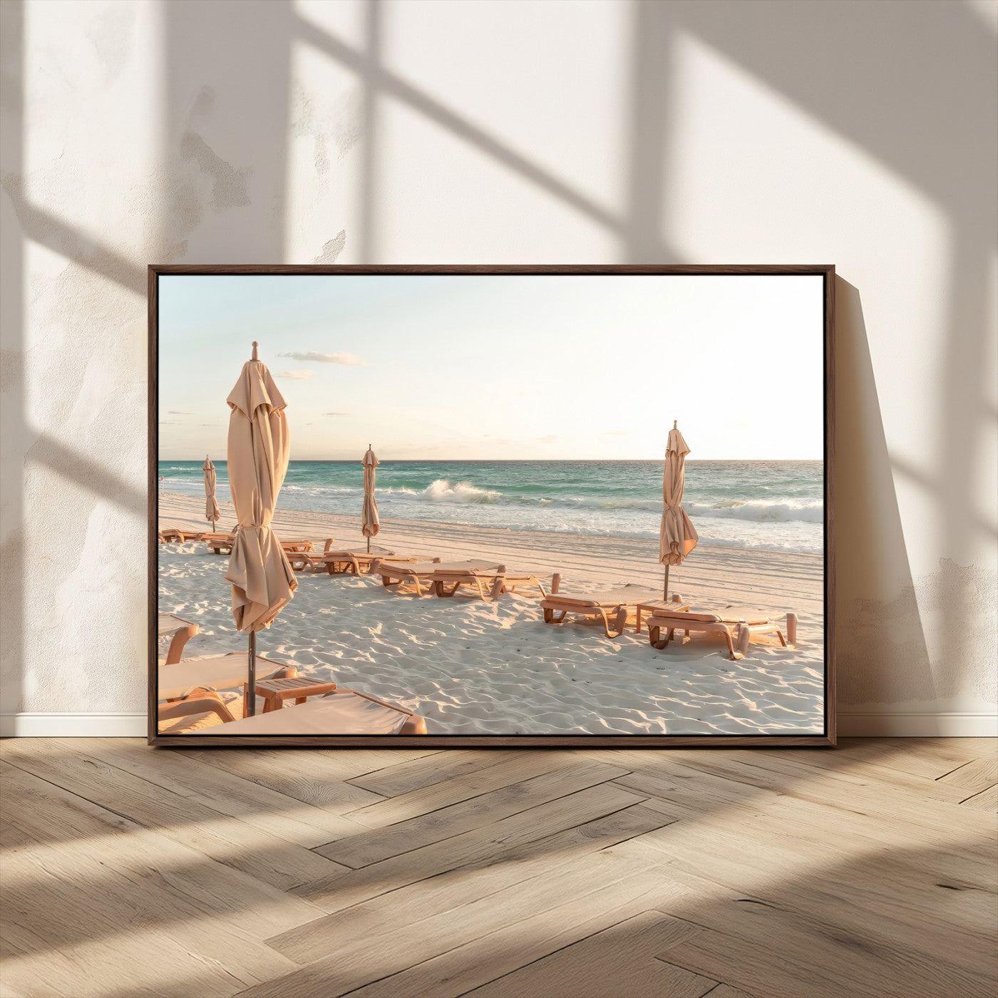 Minimalist photo of empty beach loungers and umbrellas on soft sand, ideal for calm seaside or pastel coastal-style home decor.