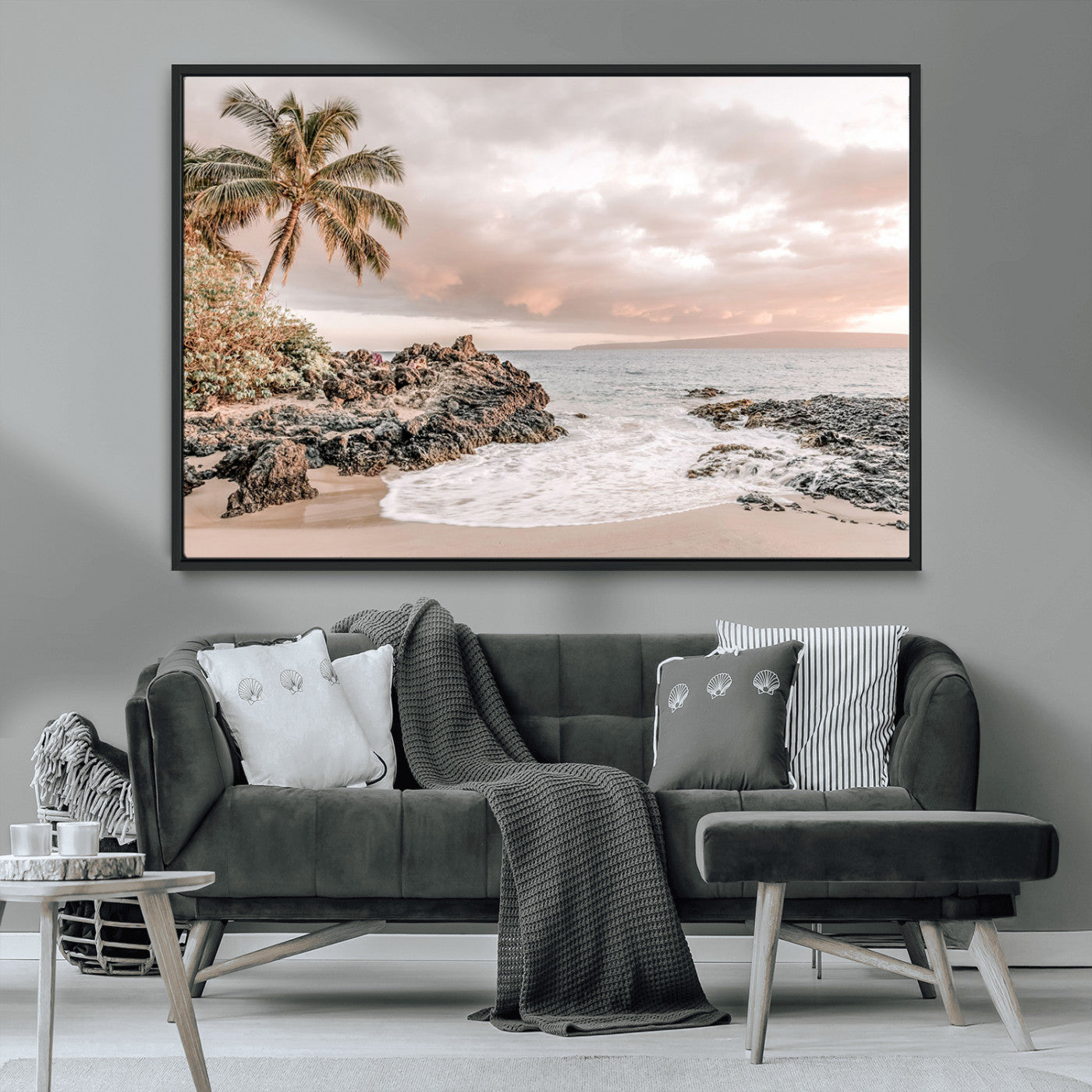 A peaceful beach scene with a palm tree and rocks, soft waves washing onto the shore under a soft pastel sky at sunset.