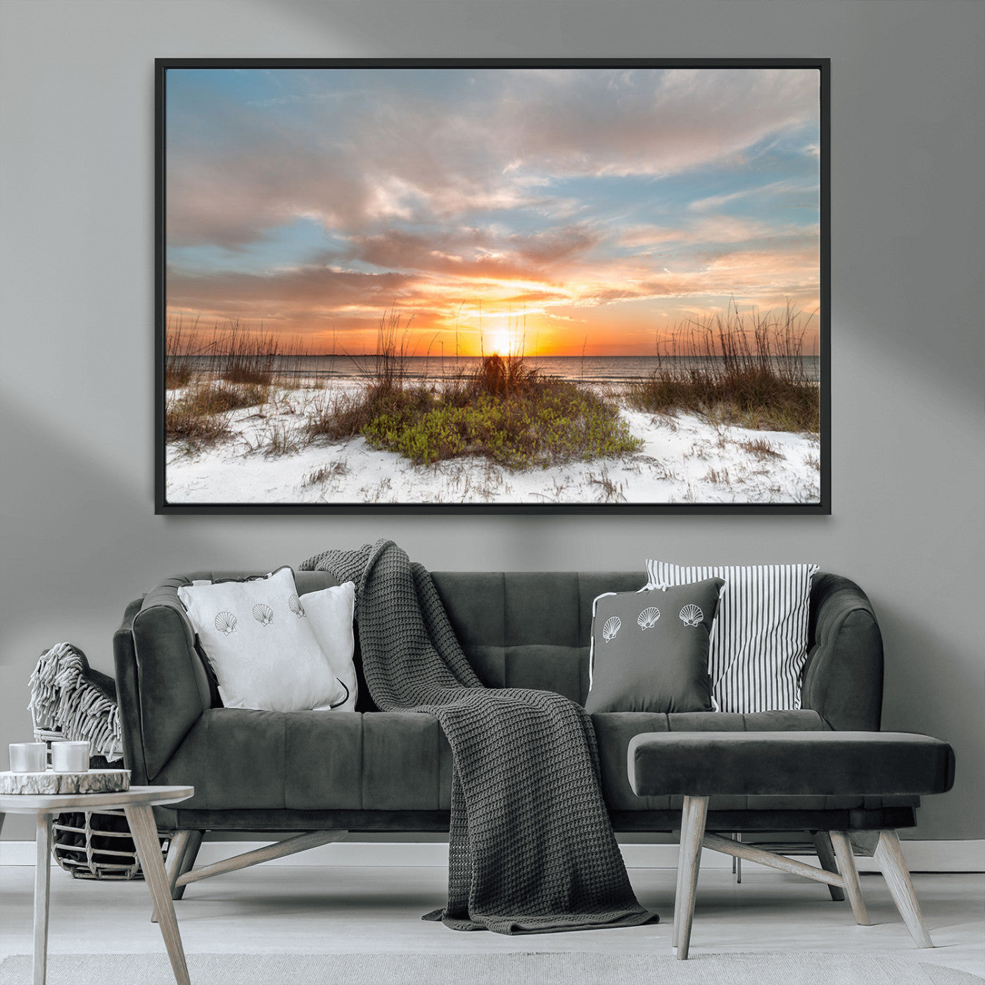 A tranquil beach scene featuring golden sunset hues over the water, with grasses in the foreground and a peaceful, serene atmosphere.