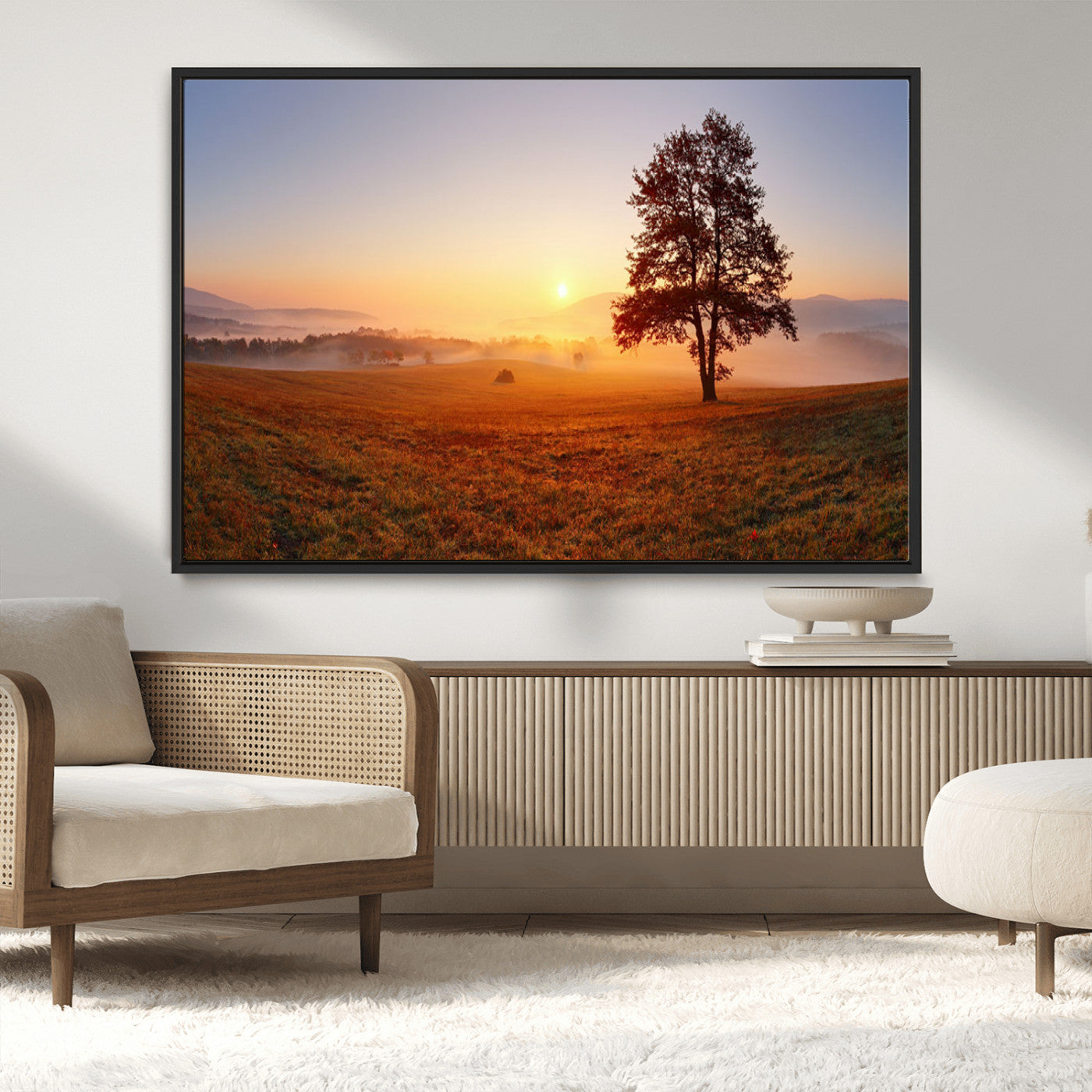 A tranquil landscape at sunrise with a mist-covered field and a lone tree, creating a peaceful and natural atmosphere.