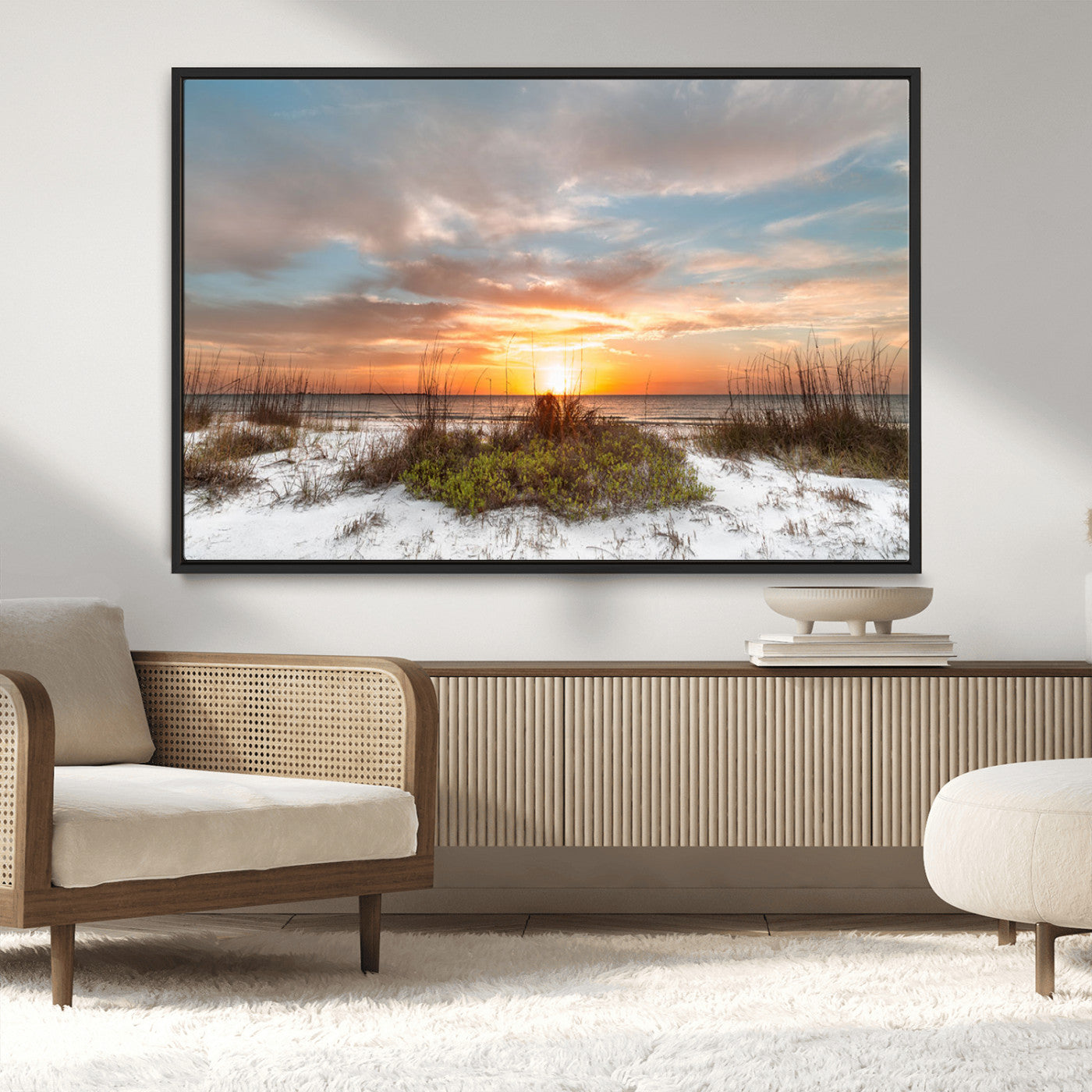 A tranquil beach scene featuring golden sunset hues over the water, with grasses in the foreground and a peaceful, serene atmosphere.