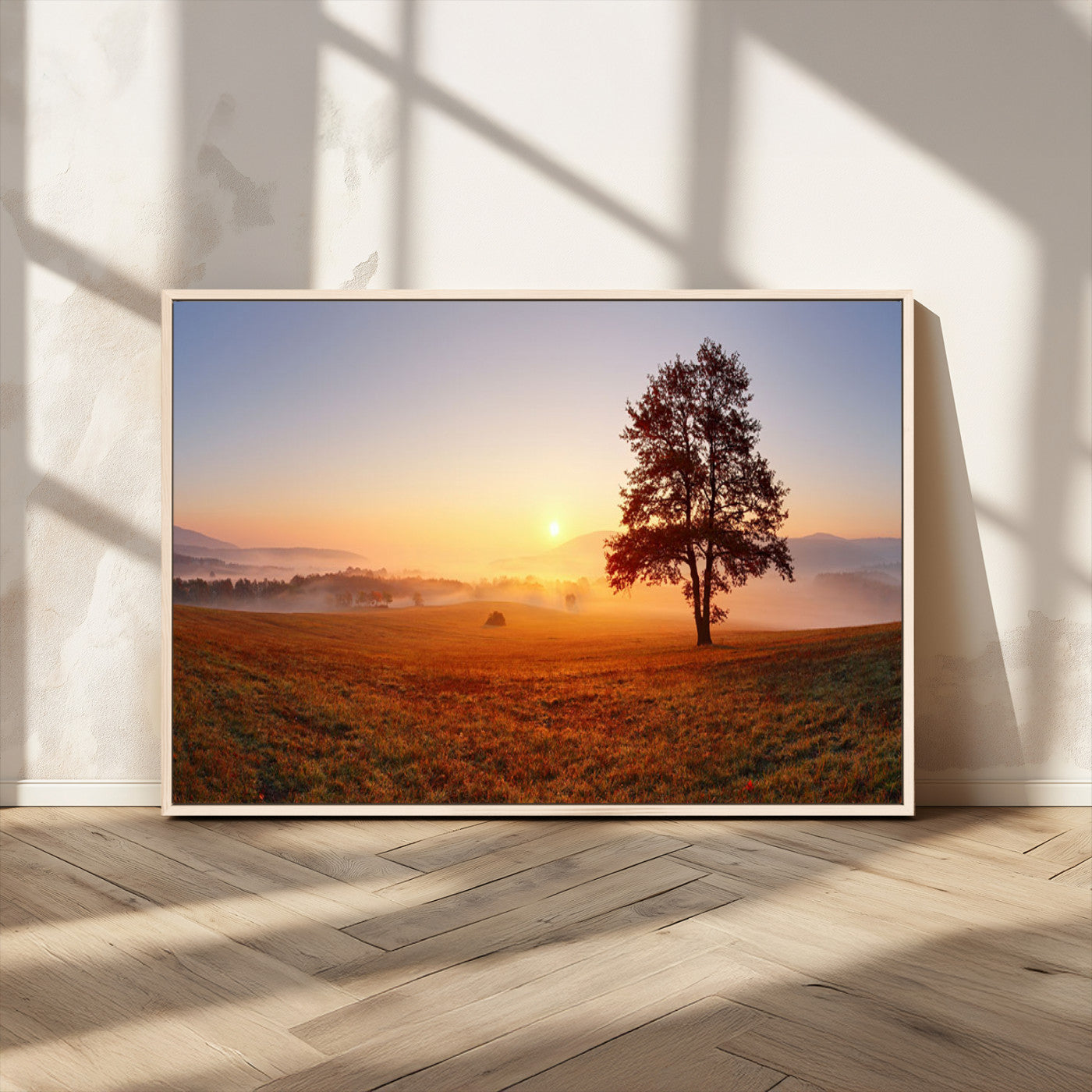 A tranquil landscape at sunrise with a mist-covered field and a lone tree, creating a peaceful and natural atmosphere.