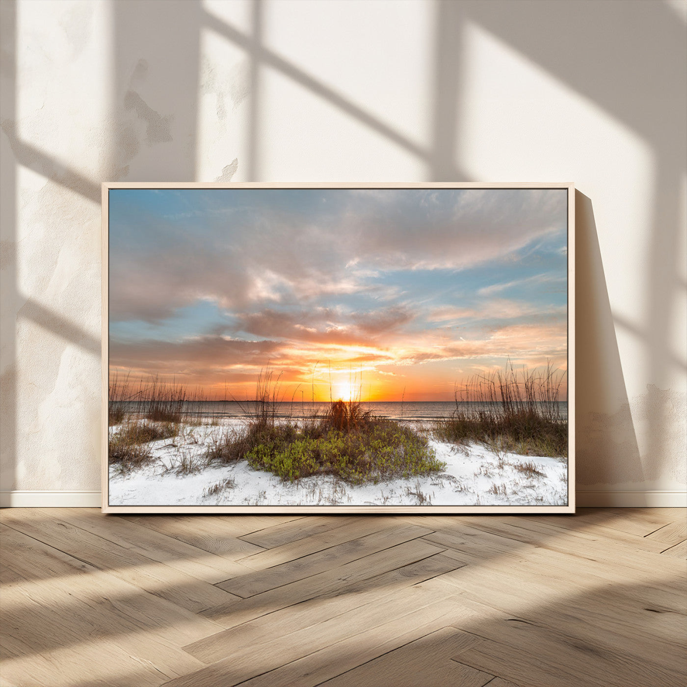 A tranquil beach scene featuring golden sunset hues over the water, with grasses in the foreground and a peaceful, serene atmosphere.