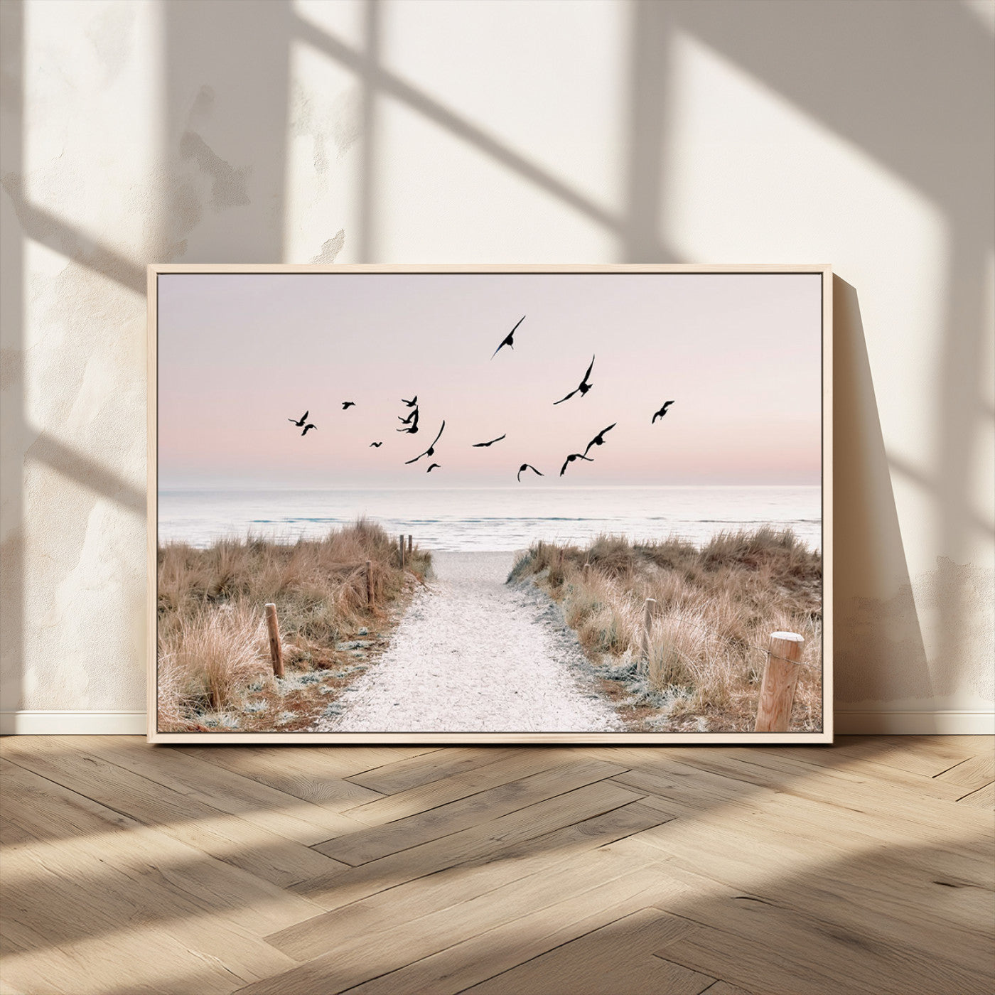 A peaceful coastal pathway leading to the ocean, with birds flying across a soft pastel sky, creating a calm and scenic beach atmosphere.
