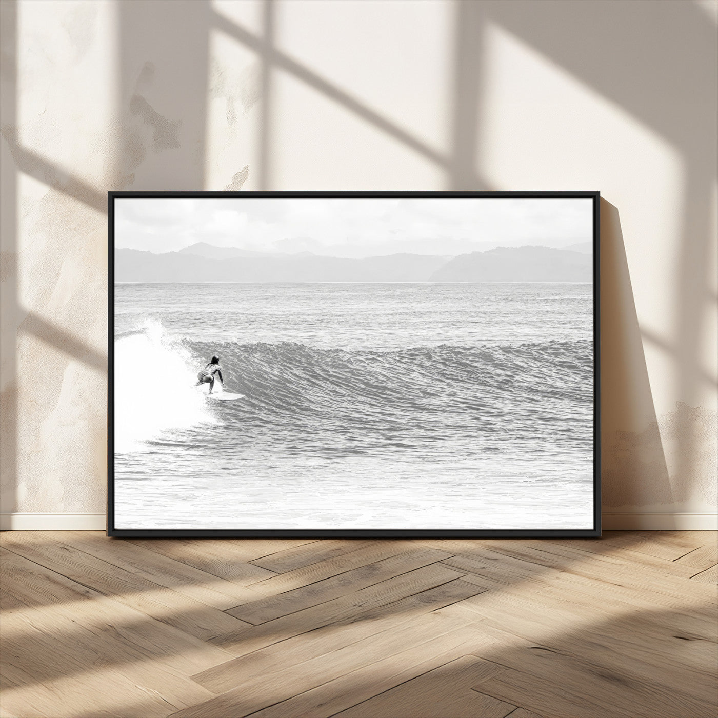 Monochrome photo of a surfer riding a wave with distant mountains, ideal for coastal motion or black and white surf-themed wall decor.