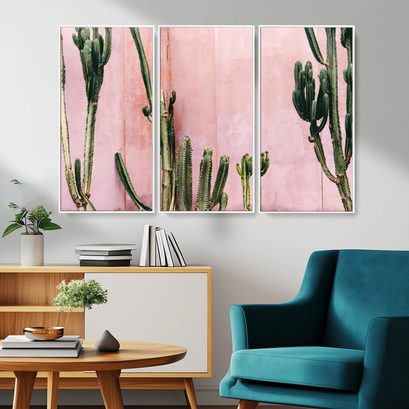 Framed canvas of tall green cacti against a soft pink wall, ideal for modern desert or colorful southwest-inspired home decor.