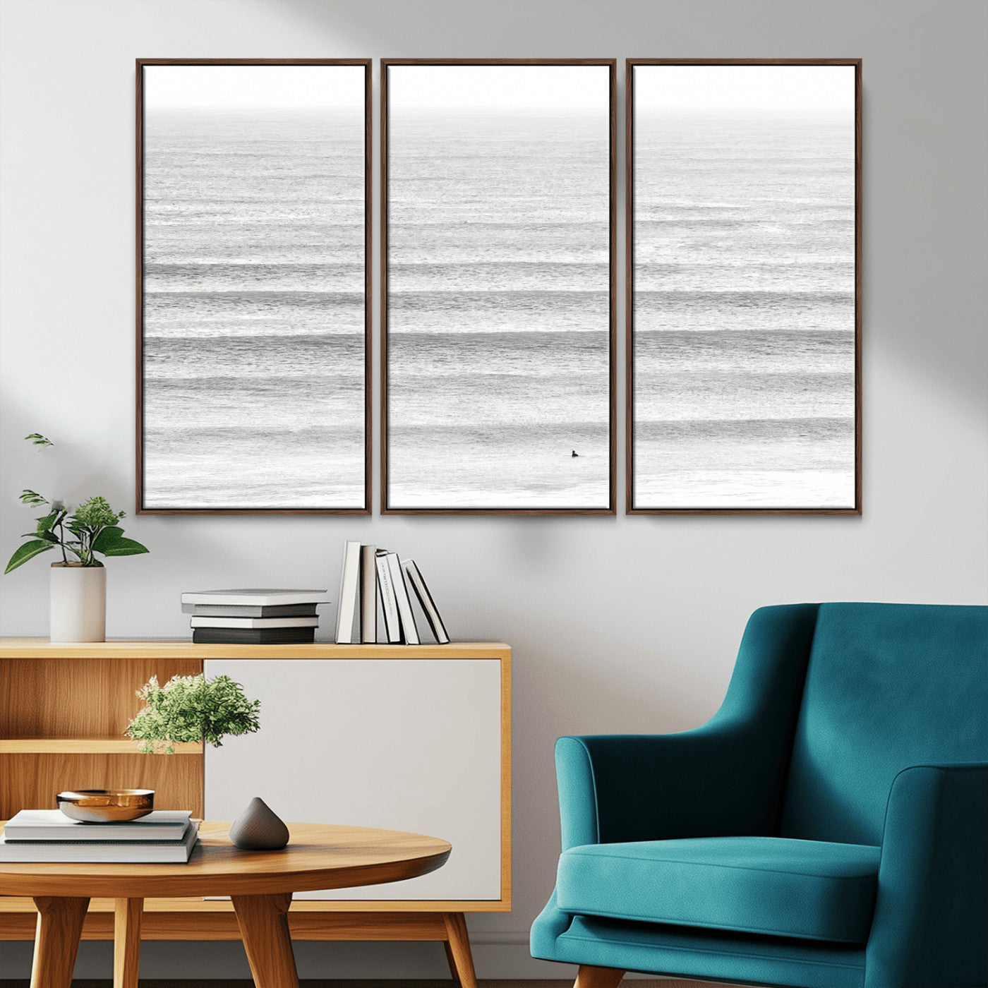 Monochrome photo of a lone surfer in calm layered waves, perfect for minimalist coastal or moody ocean-inspired wall decoration.