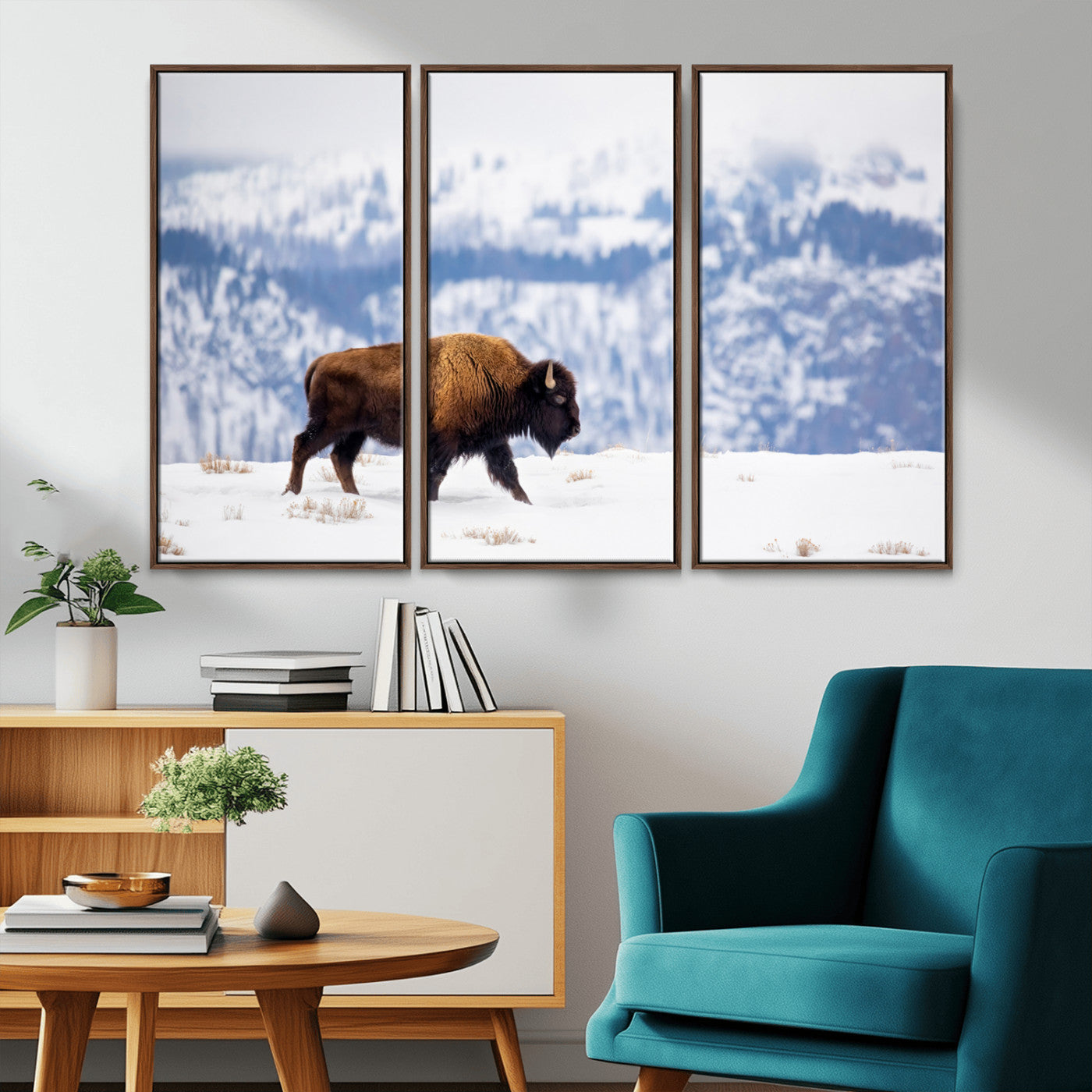 A lone bison walks across snowy ground with blue-toned mountain range behind, ideal for rustic or western farmhouse interiors.
