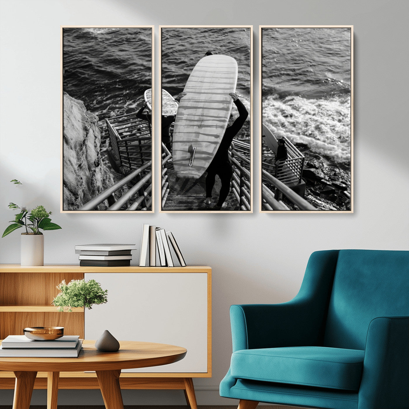 Black and white photo of surfers carrying boards down a rugged cliffside stairway, capturing a bold and adventurous coastal scene.