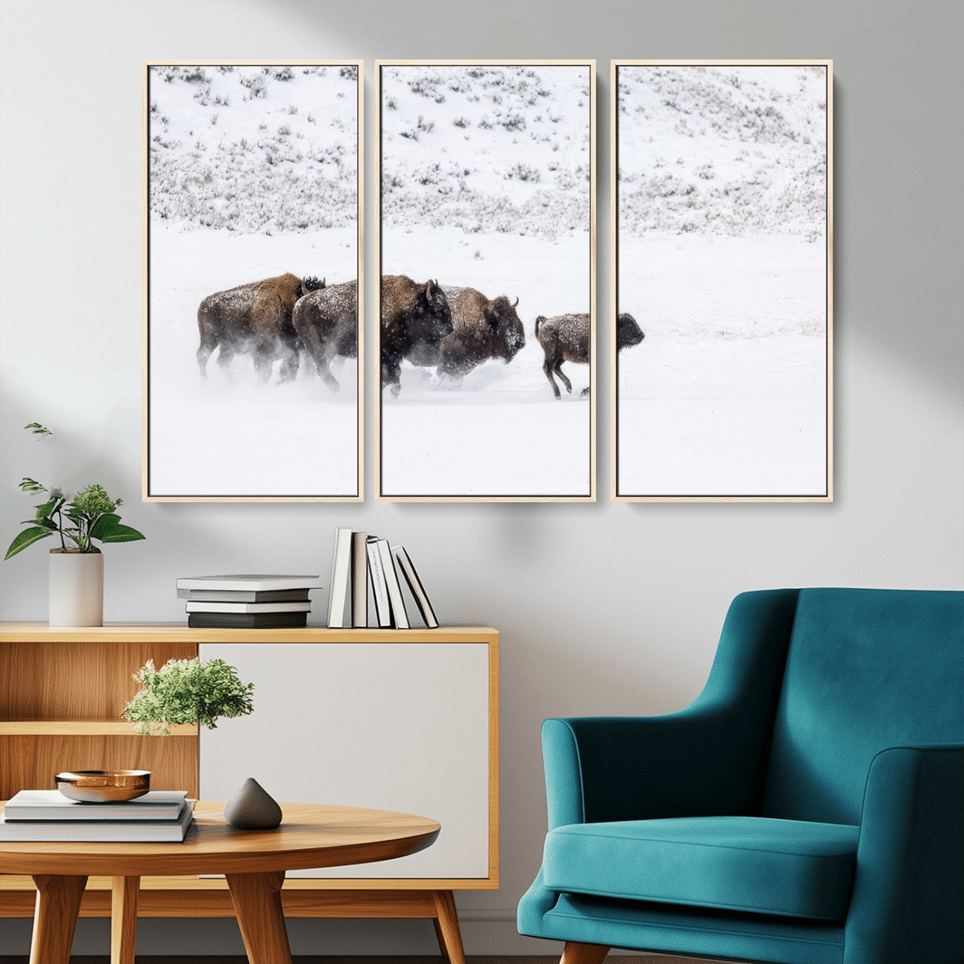 Bison herd running through a snowy open field with mountain backdrop, perfect for rustic or western-themed wall decoration.