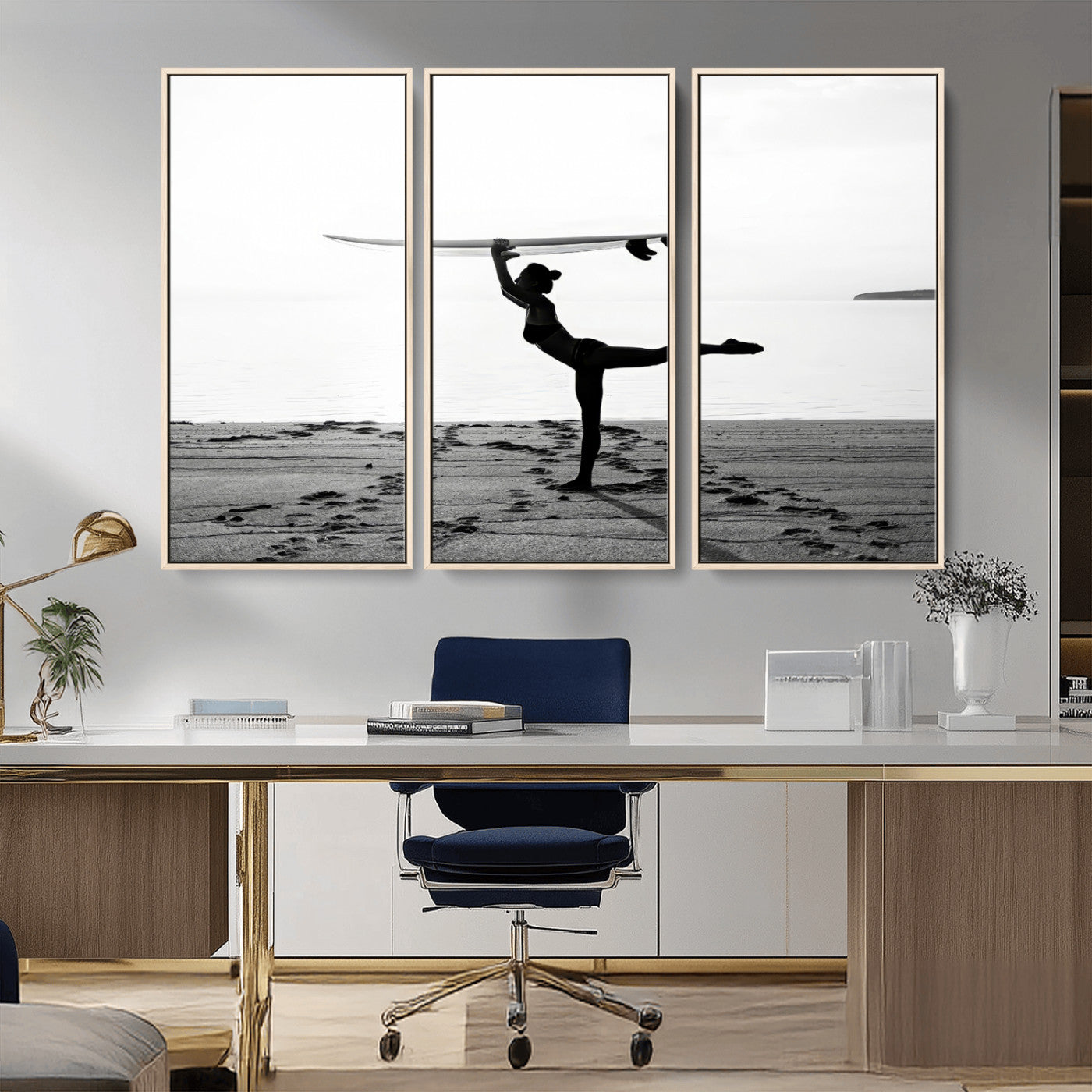 A woman balances a surfboard on her head while striking a yoga pose on the beach, silhouetted against a calm ocean horizon.