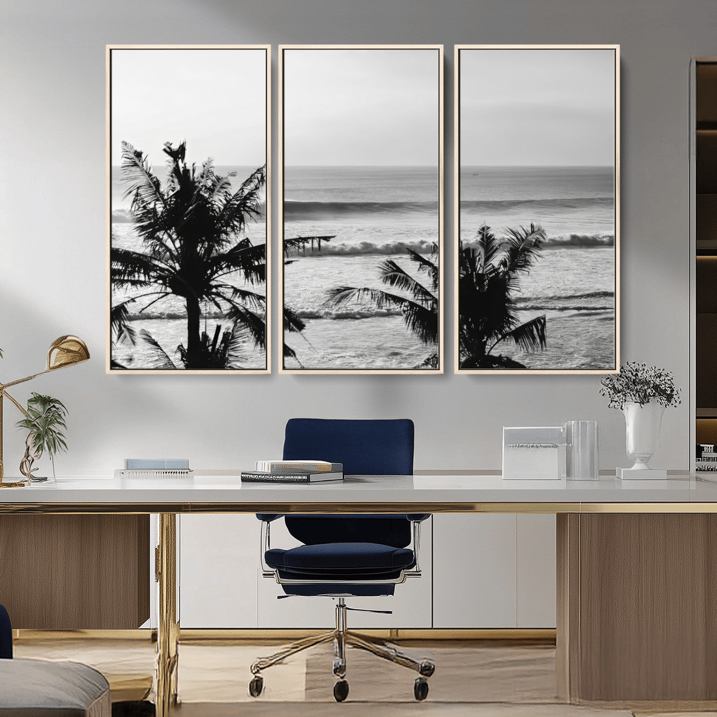Black and white view of ocean waves crashing on a tropical coastline, framed by silhouetted palm trees under a vast, open sky.
