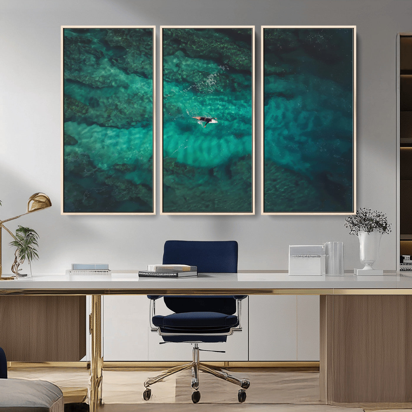 An aerial view of a solo surfer paddling through crystal-clear turquoise waters over a sunlit reef, capturing the beauty and serenity of open water surfing.