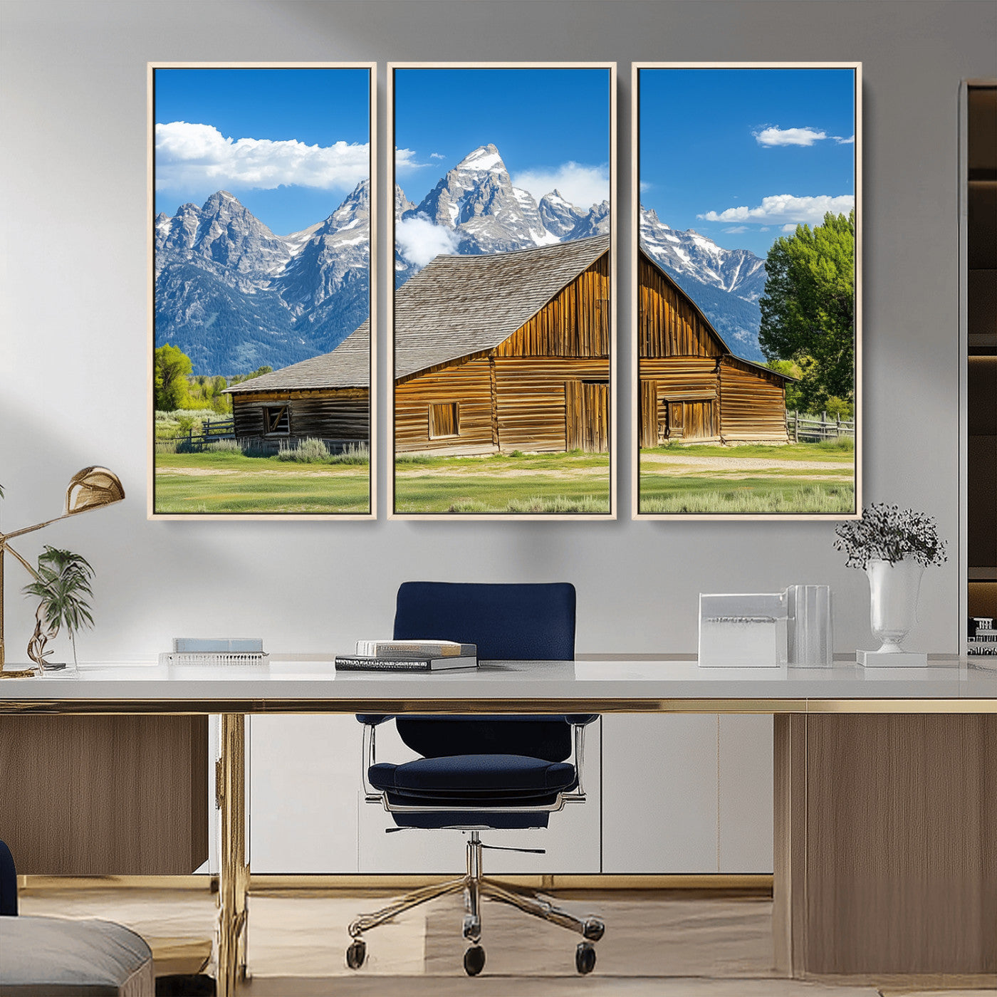 A rustic wooden barn sits in front of towering mountain peaks under a clear blue sky, perfect for farmhouse or cabin style interiors.