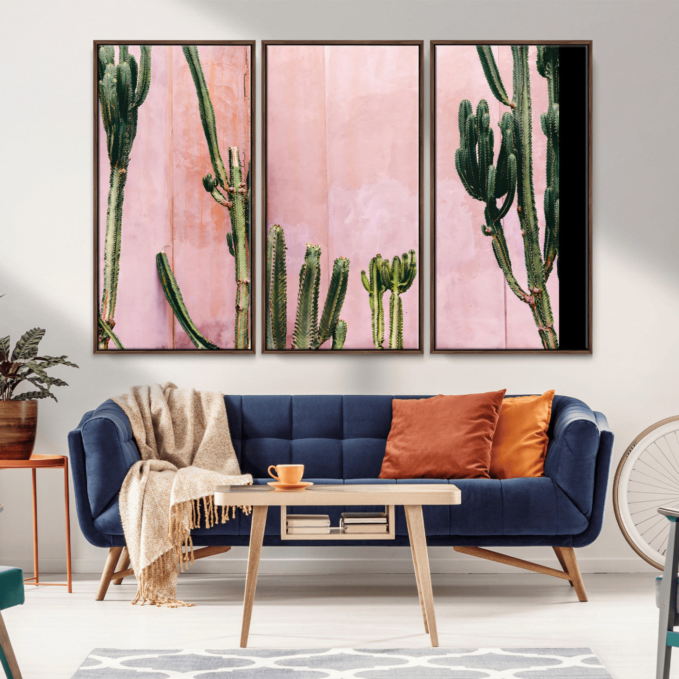 Framed canvas of tall green cacti against a soft pink wall, ideal for modern desert or colorful southwest-inspired home decor.