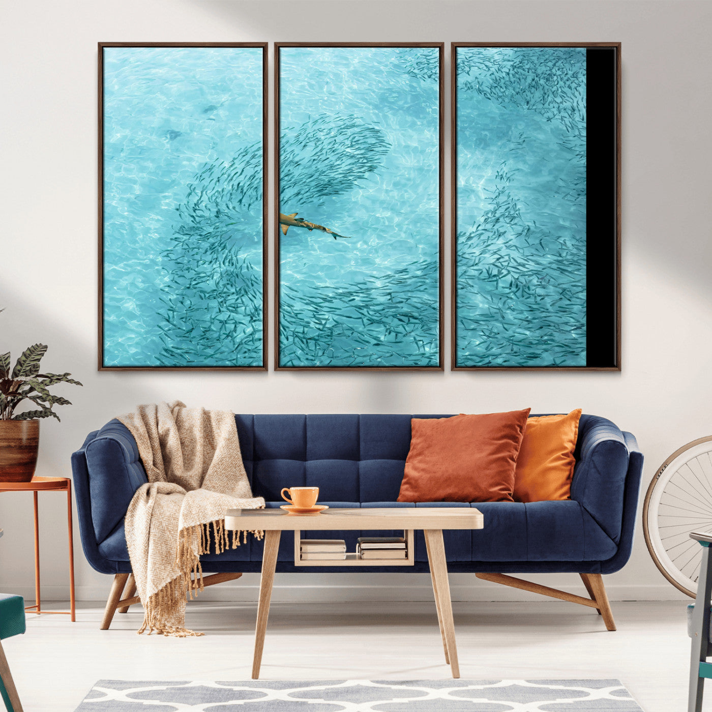 Aerial view of a shark swimming through a swirl of fish in clear turquoise waters, perfect for calm coastal or beach house decor.