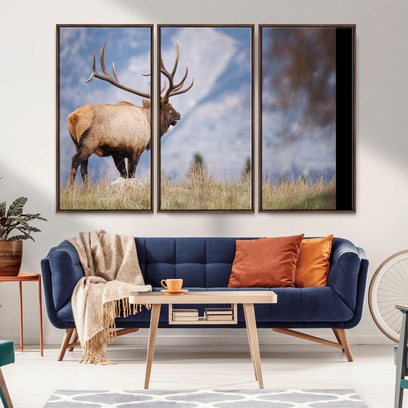 Elk with antlers standing on grass with mountain background, ideal for rustic, cabin, or lodge-inspired wall decor.