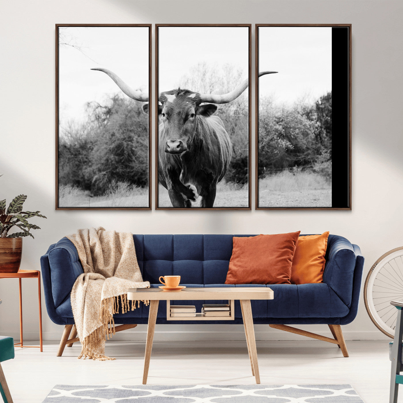Black and white photo of a longhorn cow in a field, perfect for rustic farmhouse or western-themed interior wall decoration.