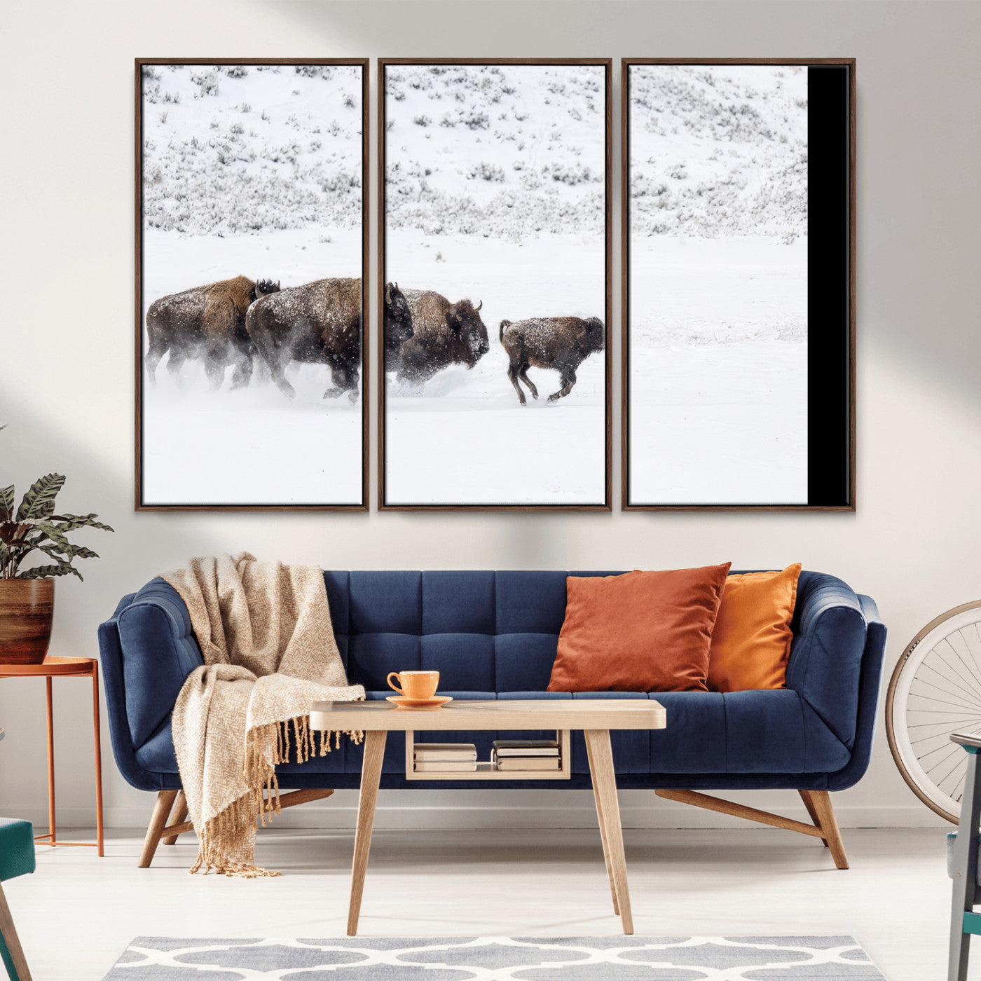 Bison herd running through a snowy open field with mountain backdrop, perfect for rustic or western-themed wall decoration.