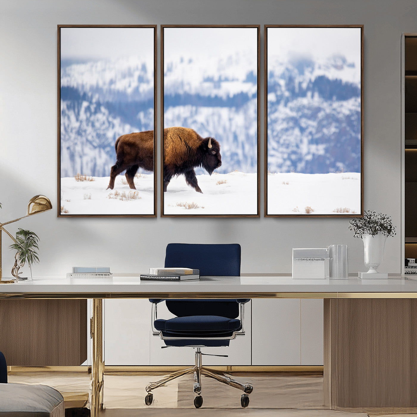 A lone bison walks across snowy ground with blue-toned mountain range behind, ideal for rustic or western farmhouse interiors.
