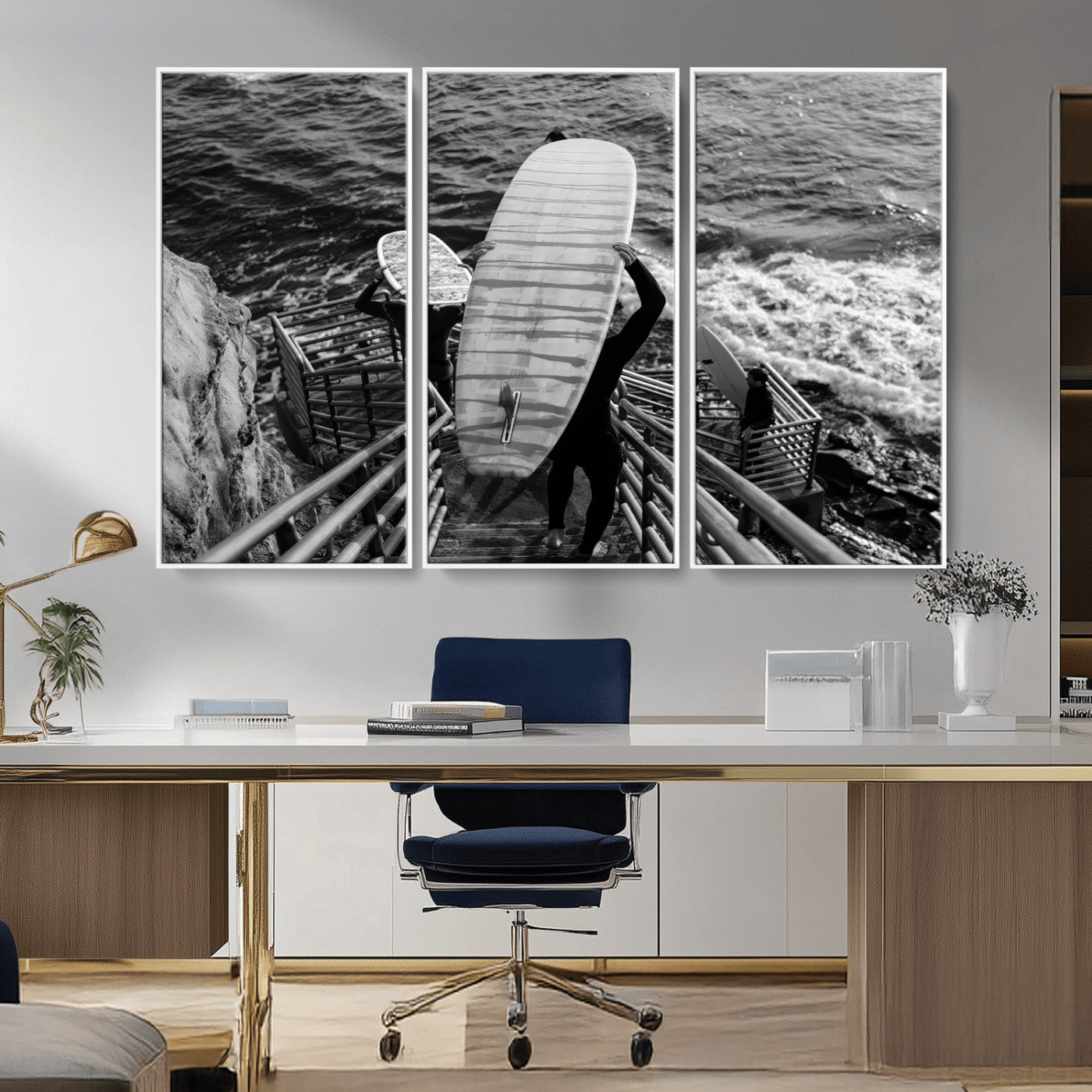 Black and white photo of surfers carrying boards down a rugged cliffside stairway, capturing a bold and adventurous coastal scene.