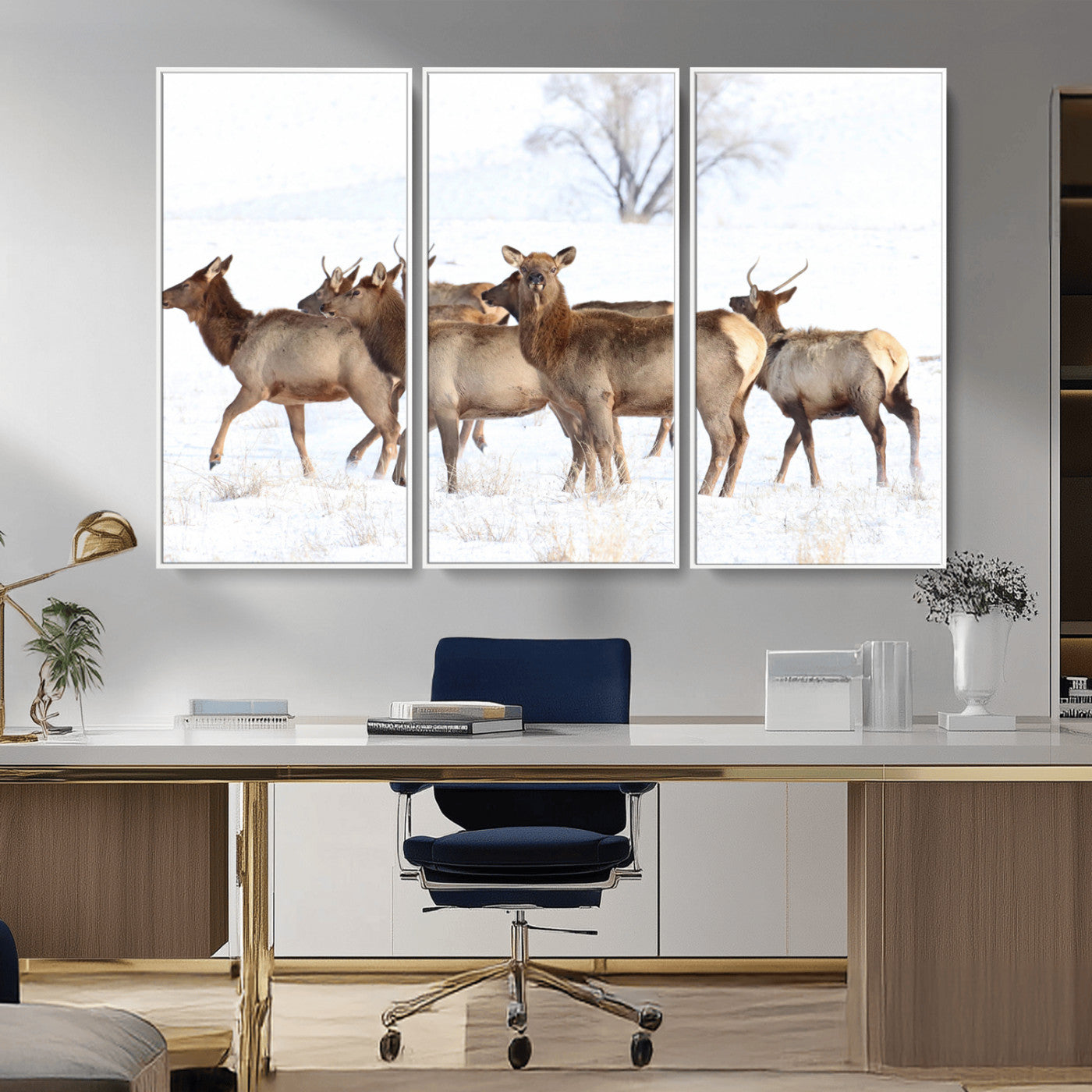 A group of elk standing on snowy terrain with a tree in the background, perfect for rustic or lodge-style winter wall decor.