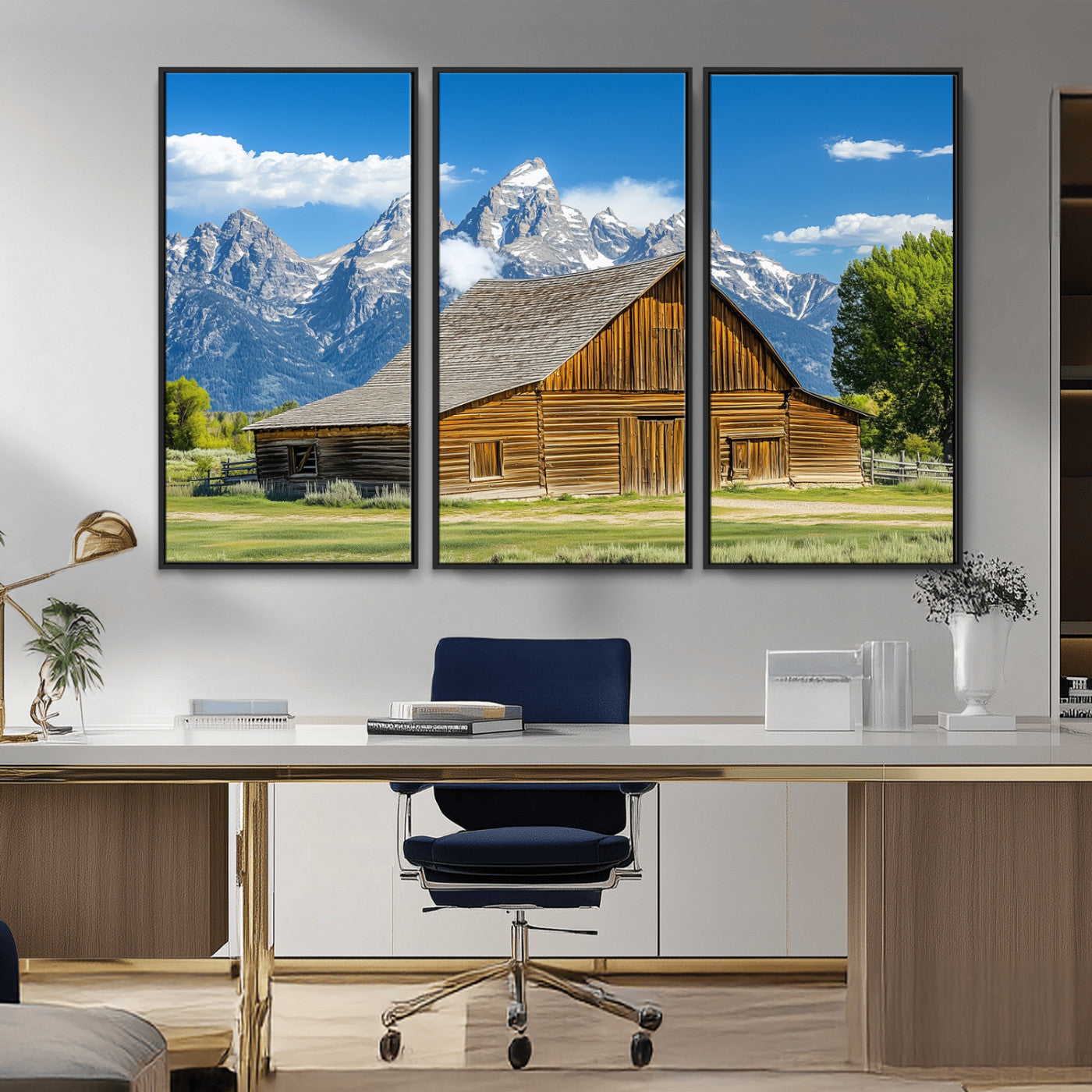 A rustic wooden barn sits in front of towering mountain peaks under a clear blue sky, perfect for farmhouse or cabin style interiors.
