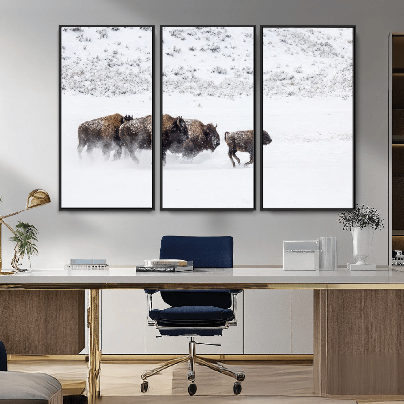 Bison herd running through a snowy open field with mountain backdrop, perfect for rustic or western-themed wall decoration.