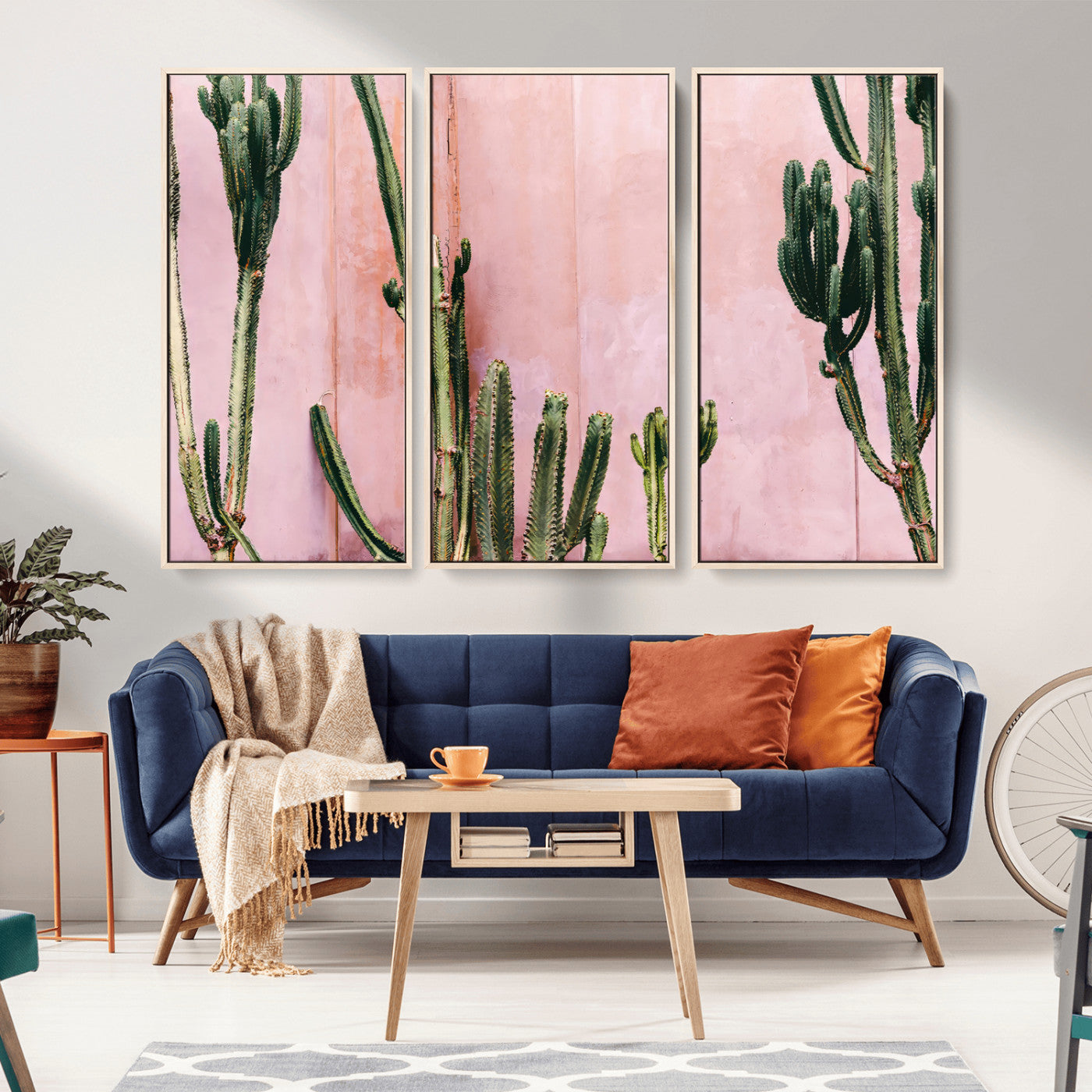 Framed canvas of tall green cacti against a soft pink wall, ideal for modern desert or colorful southwest-inspired home decor.