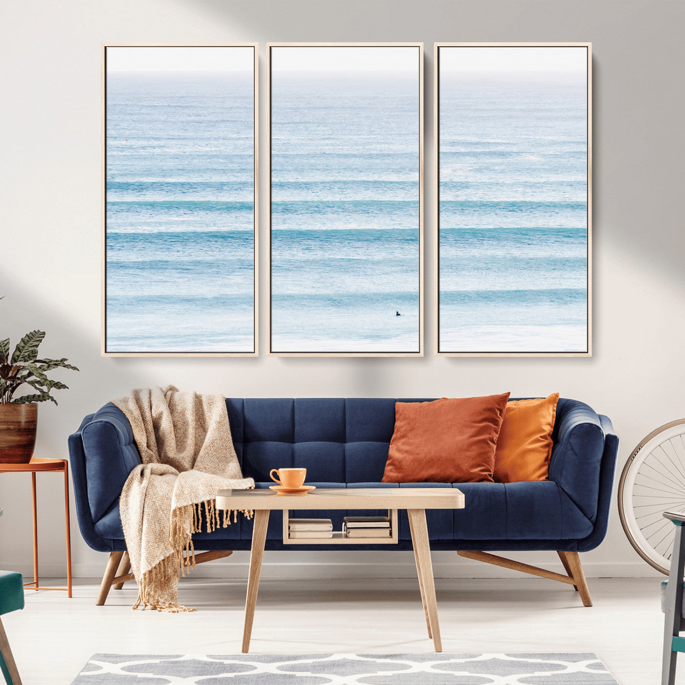 Minimalist ocean view with soft blue waves and a lone surfer, creating a serene and airy coastal aesthetic, perfect for tranquil home decor.