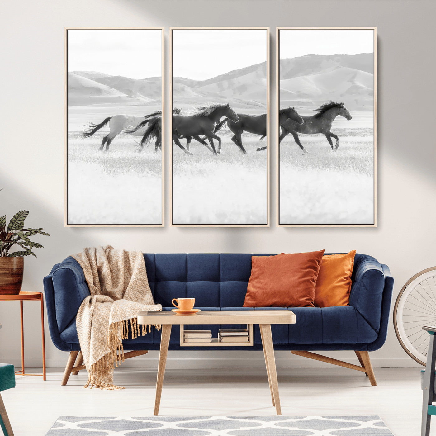 A black and white image of wild horses running freely across an open grassland, capturing the power and beauty of untamed nature in a rustic western setting.