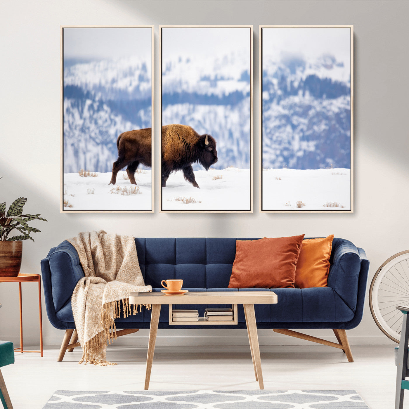 A lone bison walks across snowy ground with blue-toned mountain range behind, ideal for rustic or western farmhouse interiors.