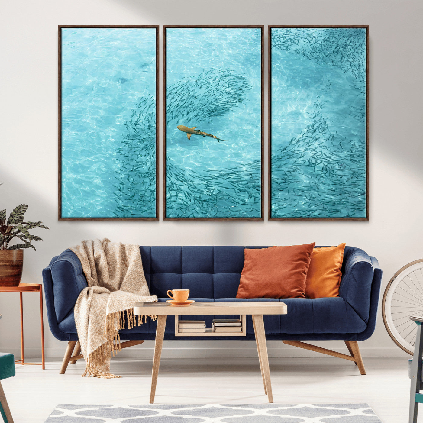 Aerial view of a shark swimming through a swirl of fish in clear turquoise waters, perfect for calm coastal or beach house decor.