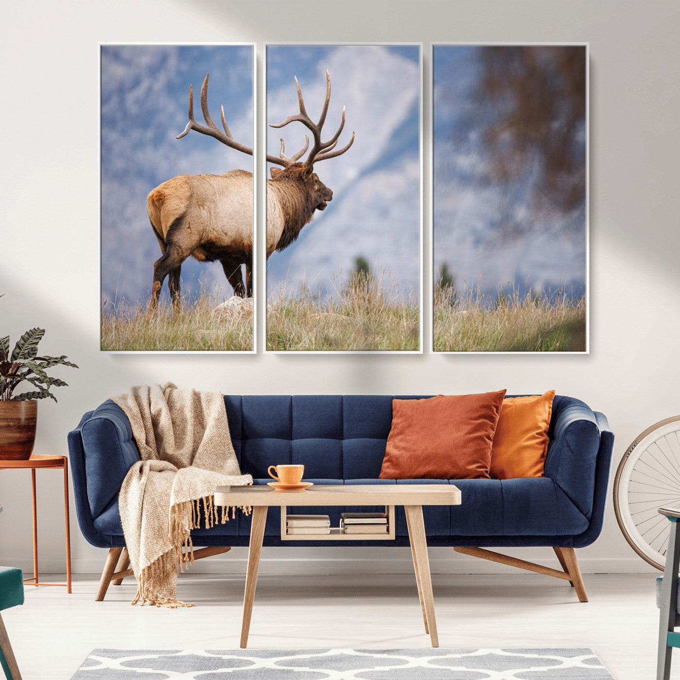 Elk with antlers standing on grass with mountain background, ideal for rustic, cabin, or lodge-inspired wall decor.