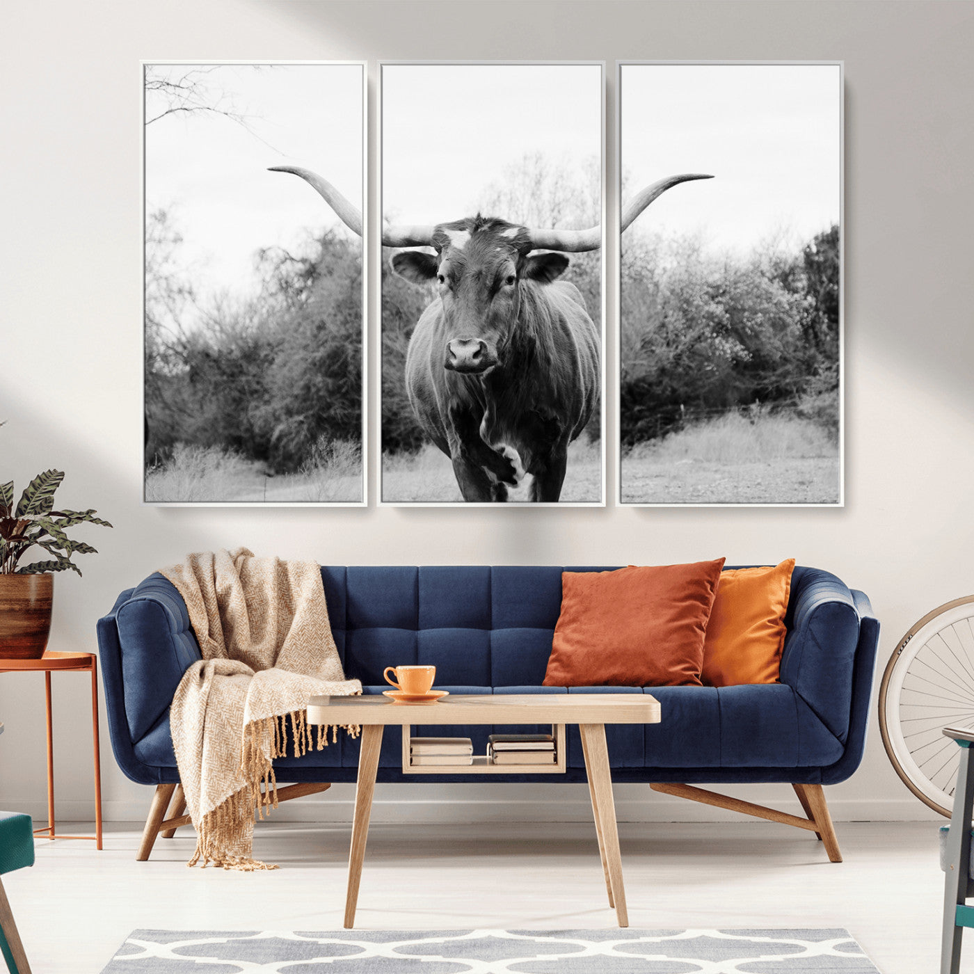 Black and white photo of a longhorn cow in a field, perfect for rustic farmhouse or western-themed interior wall decoration.