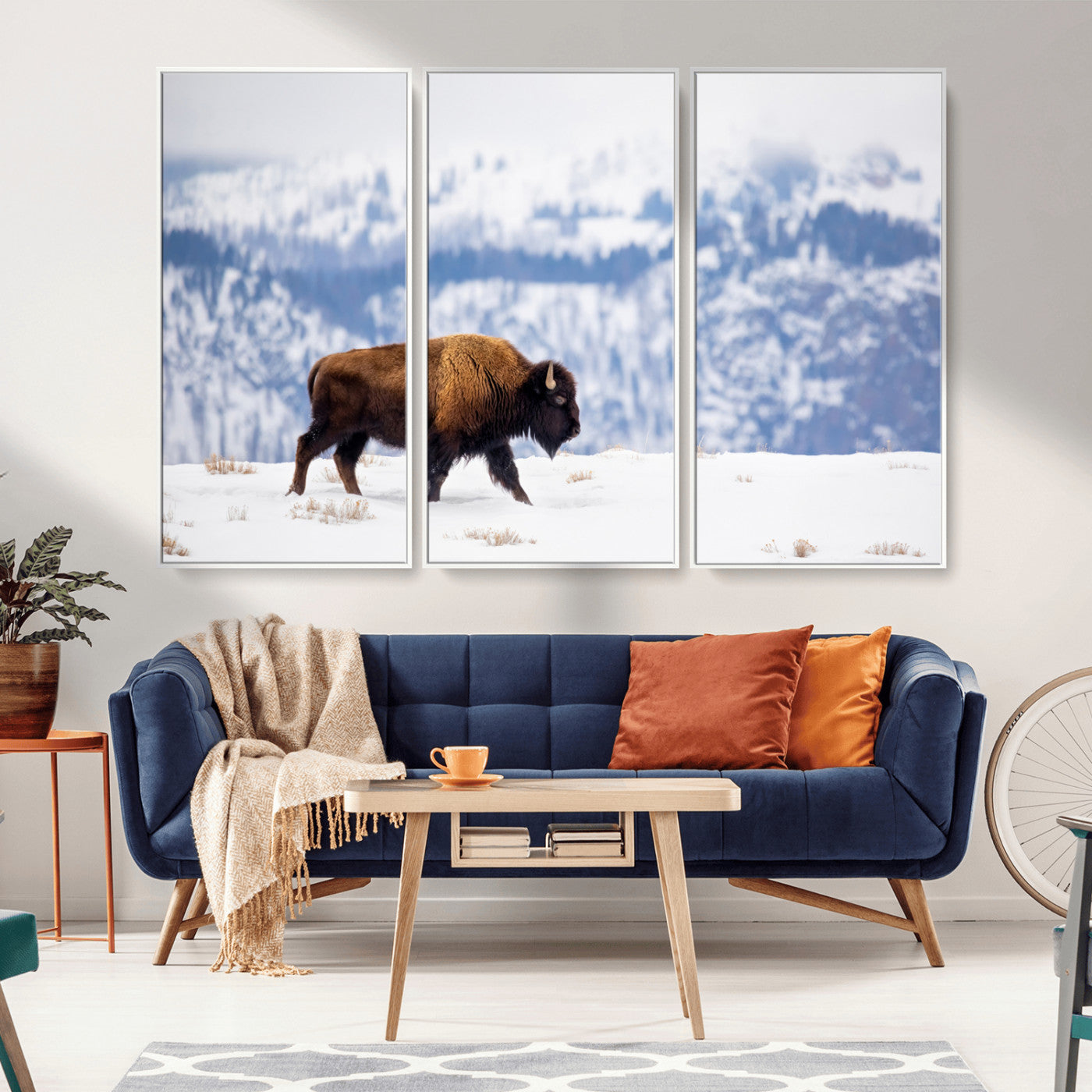 A lone bison walks across snowy ground with blue-toned mountain range behind, ideal for rustic or western farmhouse interiors.