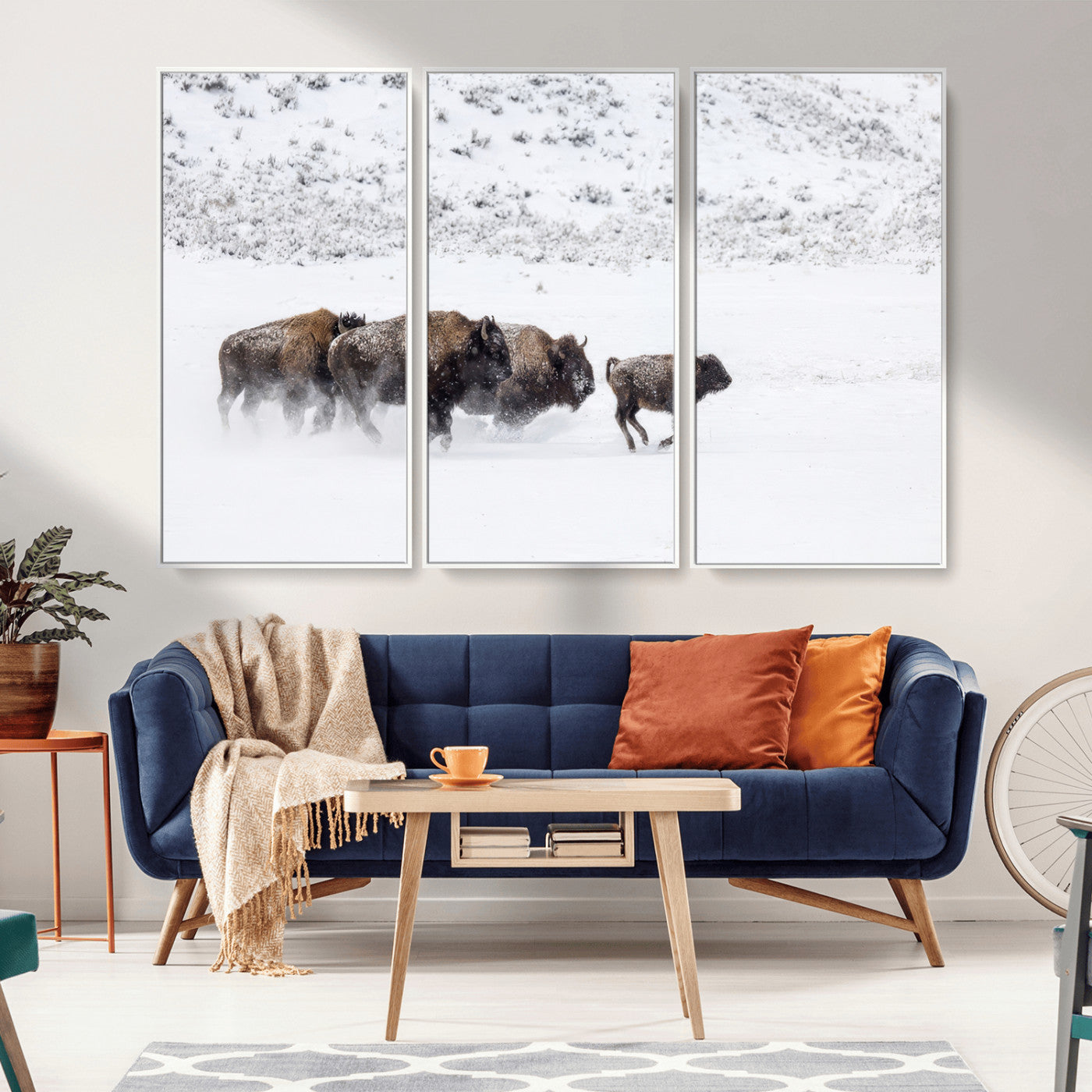 Bison herd running through a snowy open field with mountain backdrop, perfect for rustic or western-themed wall decoration.