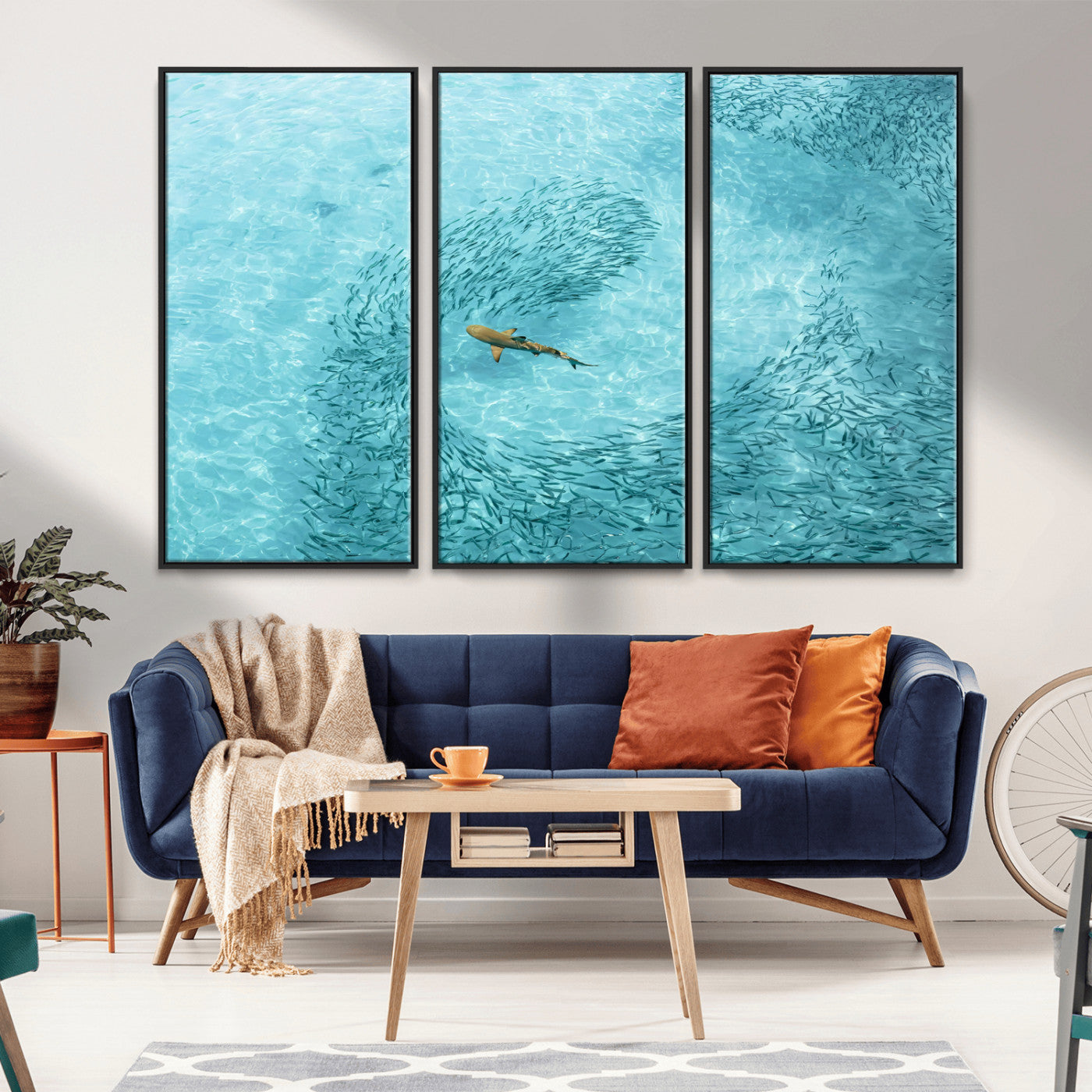 Aerial view of a shark swimming through a swirl of fish in clear turquoise waters, perfect for calm coastal or beach house decor.