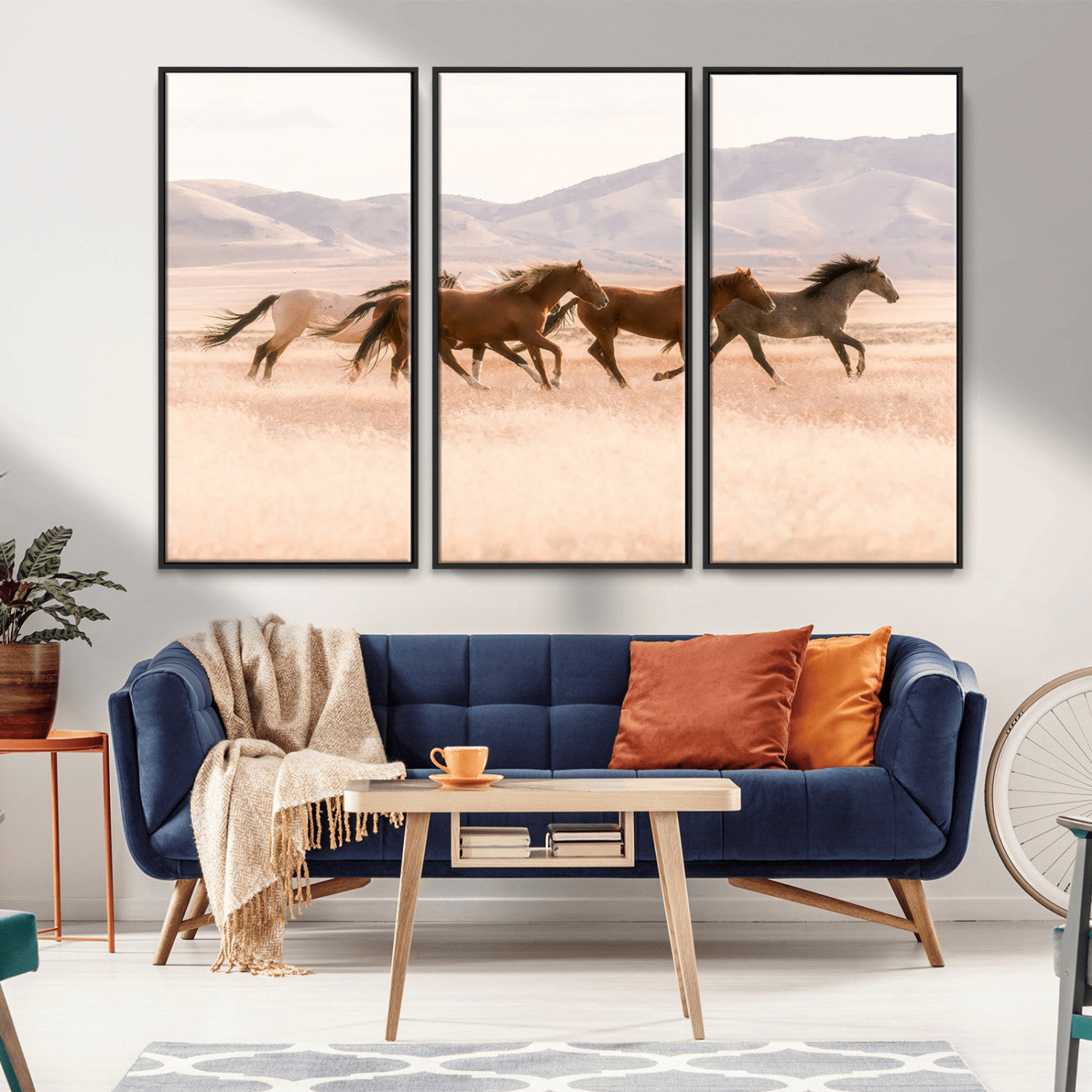 A herd of wild horses galloping through a sunlit desert plain with mountains in the background, perfect for rustic or western-themed wall decor.