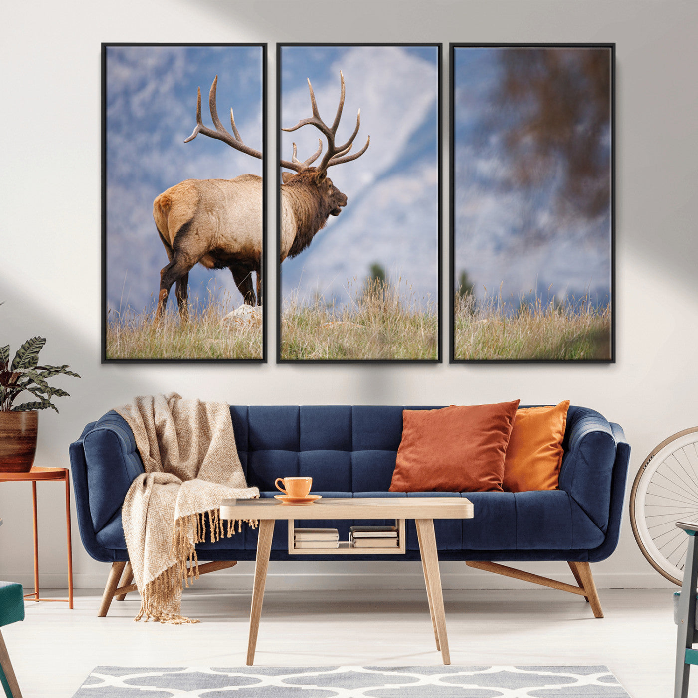 Elk with antlers standing on grass with mountain background, ideal for rustic, cabin, or lodge-inspired wall decor.