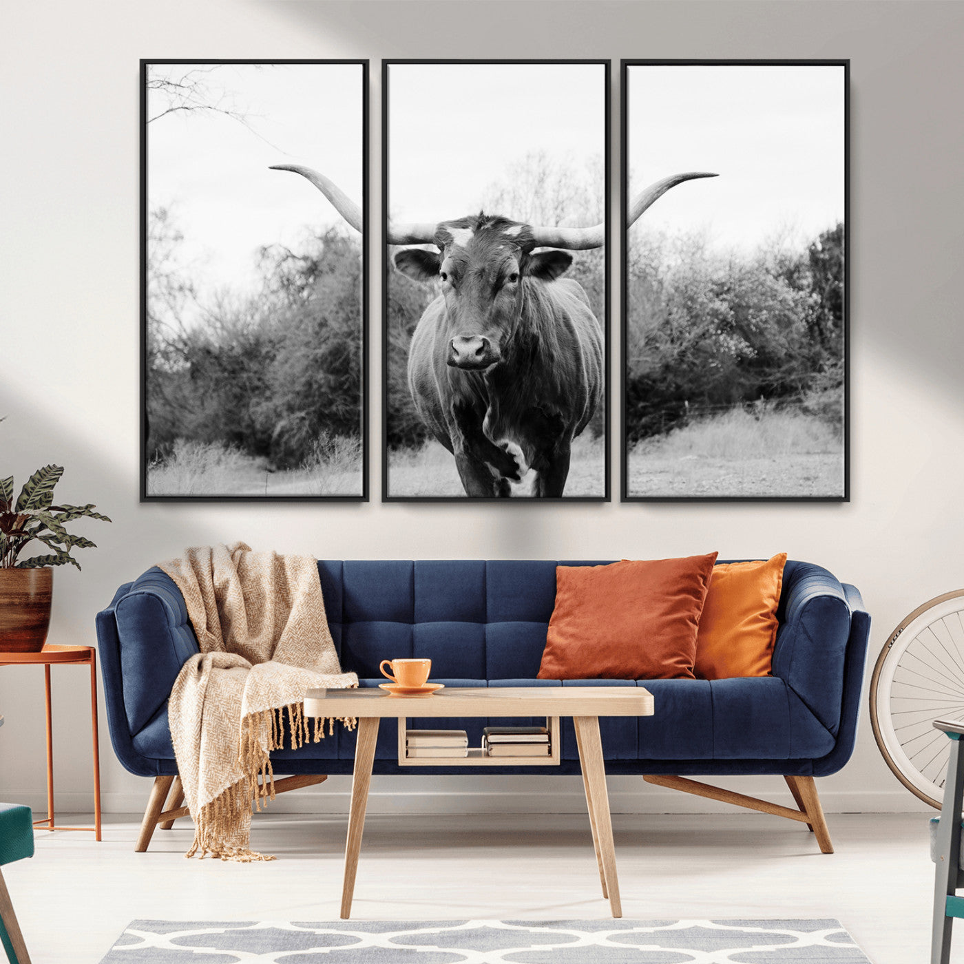 Black and white photo of a longhorn cow in a field, perfect for rustic farmhouse or western-themed interior wall decoration.