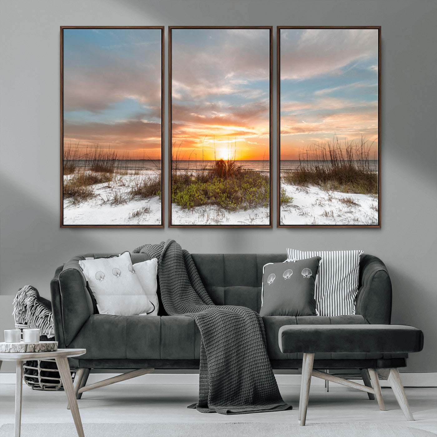A tranquil beach scene featuring golden sunset hues over the water, with grasses in the foreground and a peaceful, serene atmosphere.