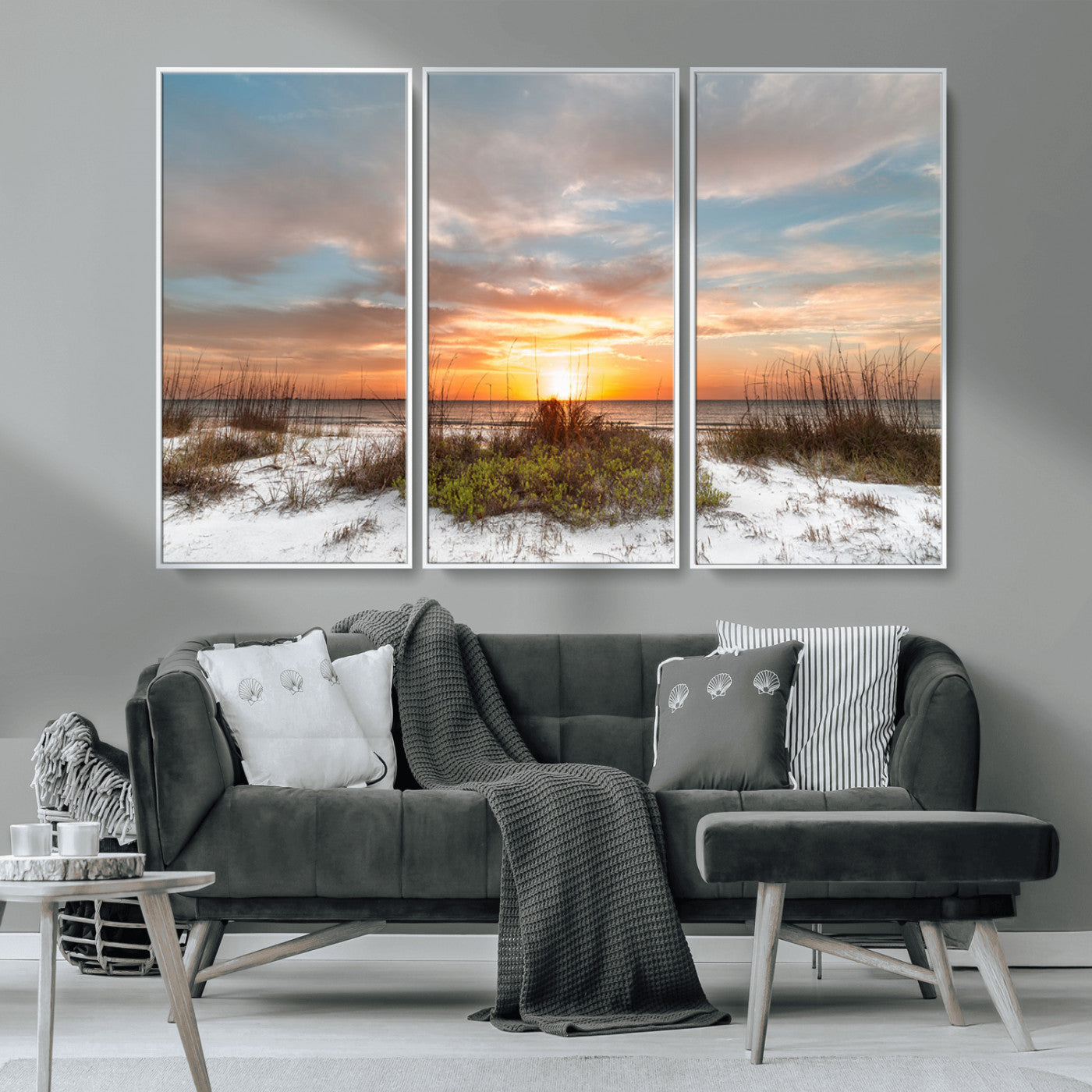 A tranquil beach scene featuring golden sunset hues over the water, with grasses in the foreground and a peaceful, serene atmosphere.