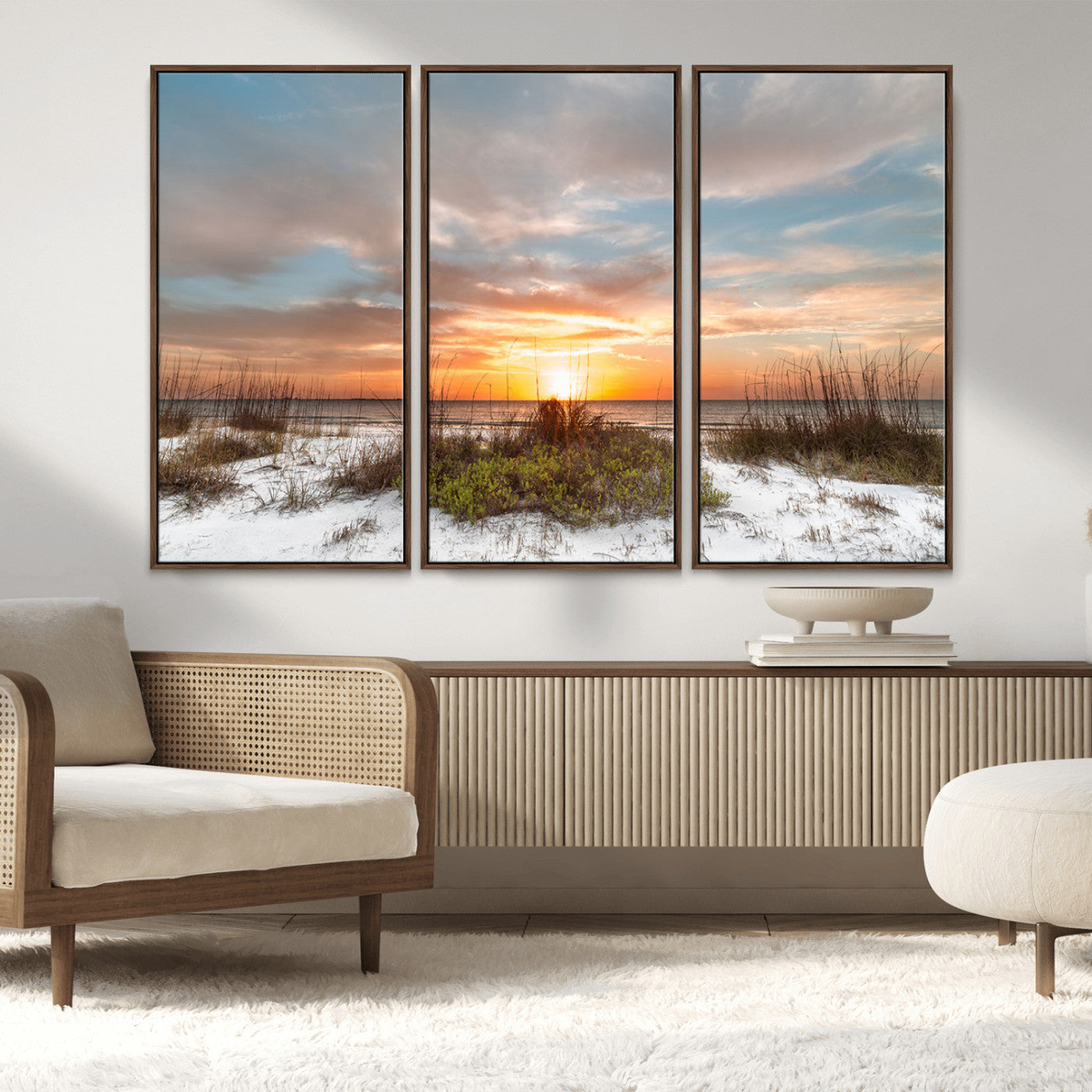 A tranquil beach scene featuring golden sunset hues over the water, with grasses in the foreground and a peaceful, serene atmosphere.