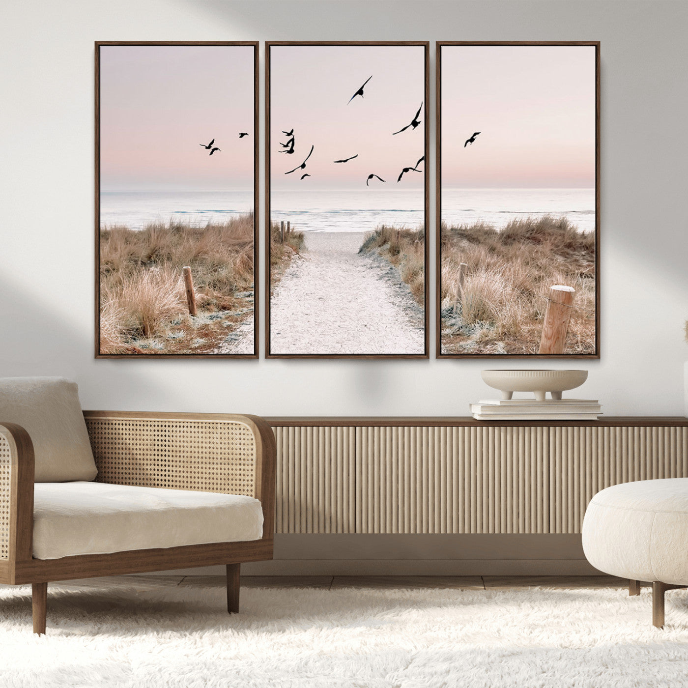 A peaceful coastal pathway leading to the ocean, with birds flying across a soft pastel sky, creating a calm and scenic beach atmosphere.