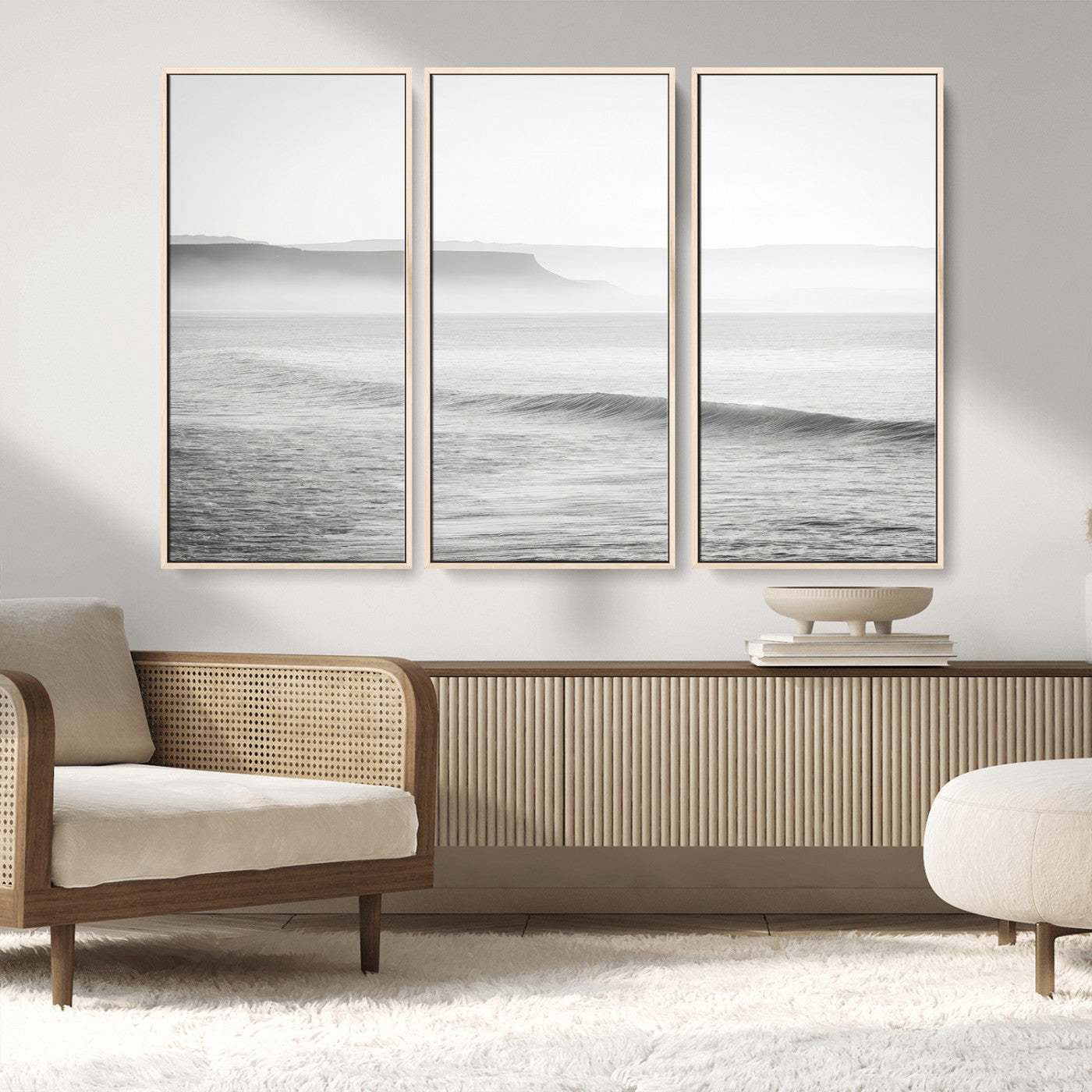 A black and white minimalist seascape featuring soft rolling waves and misty distant cliffs, creating a serene and timeless coastal atmosphere.