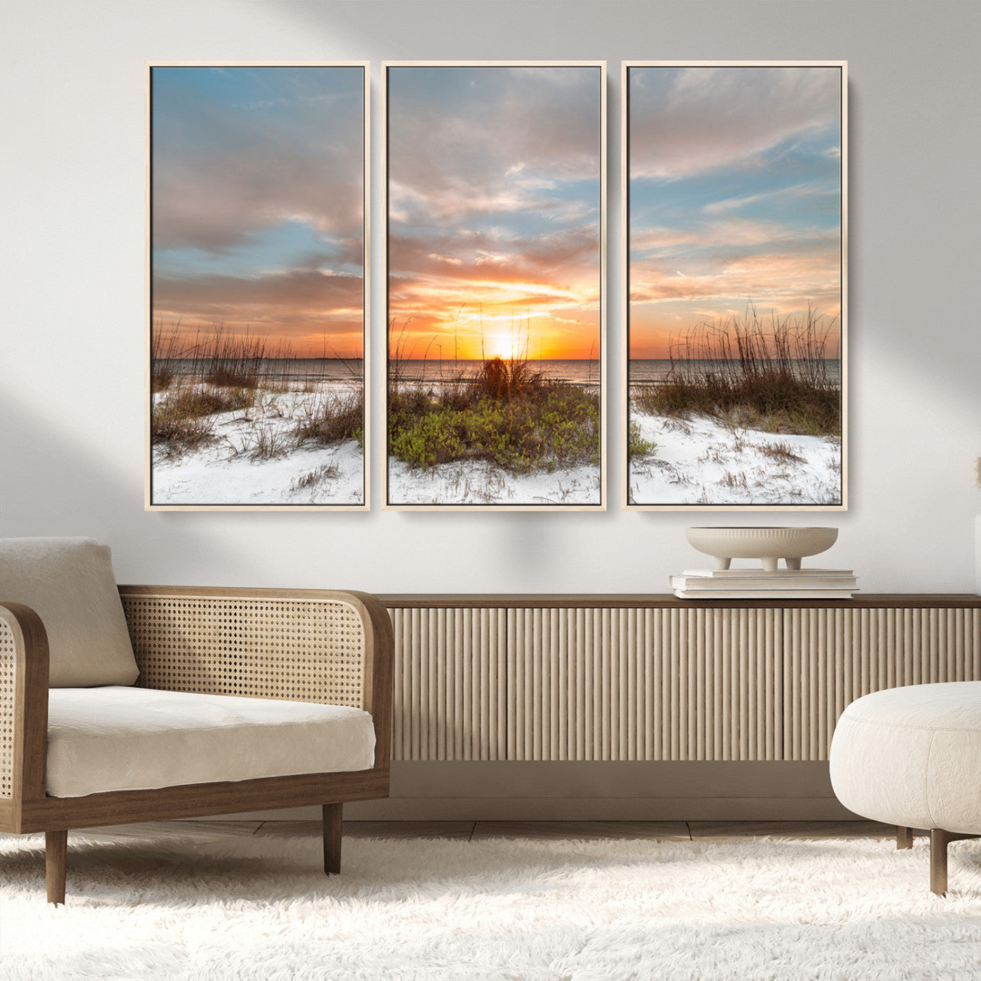 A tranquil beach scene featuring golden sunset hues over the water, with grasses in the foreground and a peaceful, serene atmosphere.