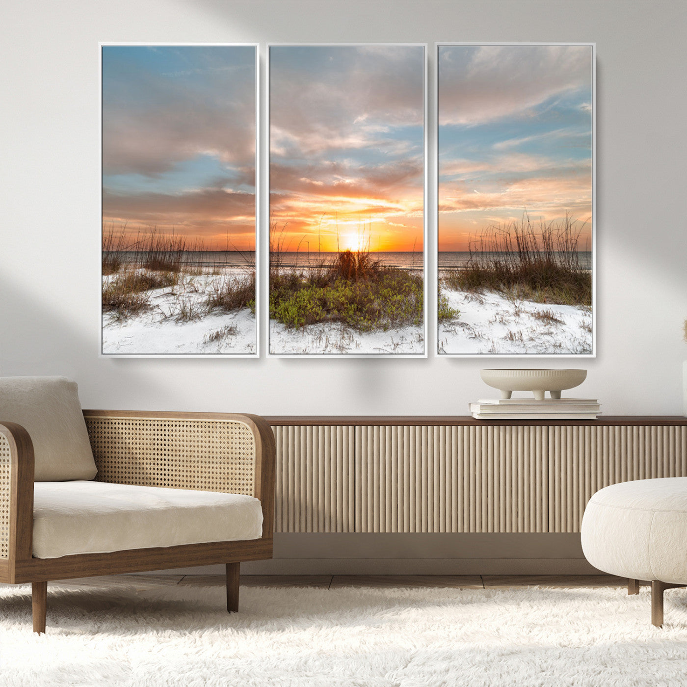 A tranquil beach scene featuring golden sunset hues over the water, with grasses in the foreground and a peaceful, serene atmosphere.