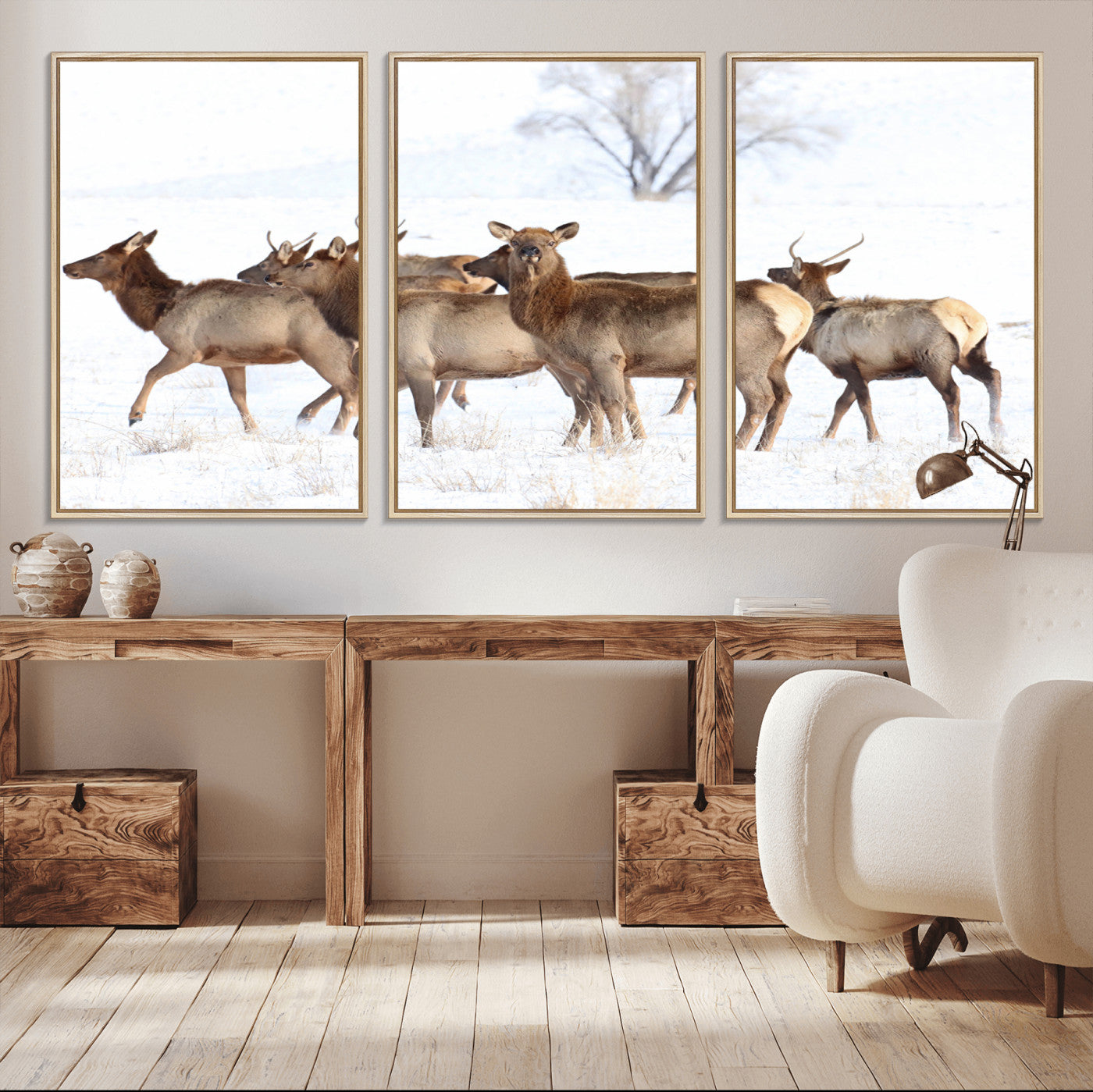 A group of elk standing on snowy terrain with a tree in the background, perfect for rustic or lodge-style winter wall decor.