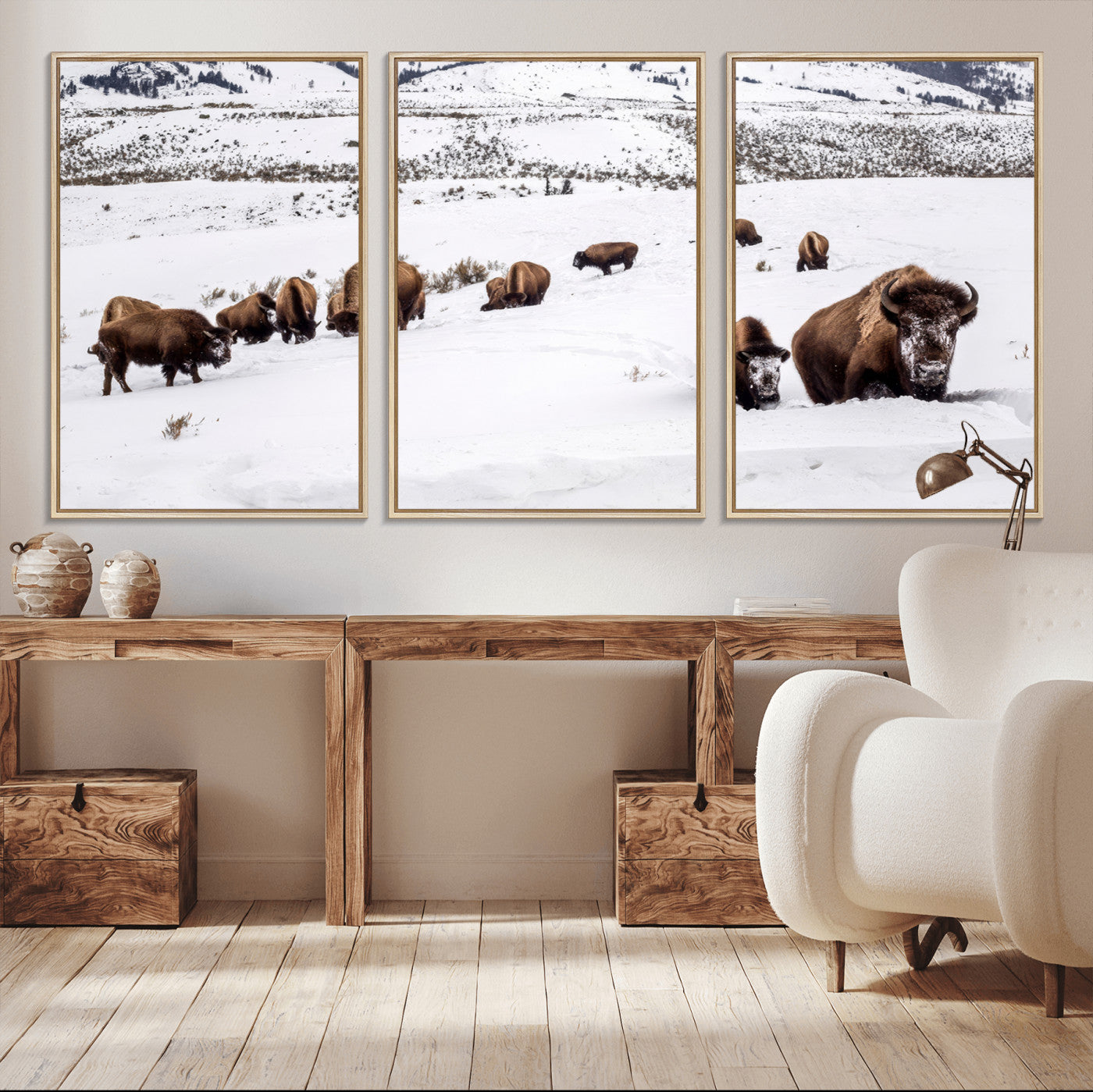 A herd of bison walking through deep snow in a mountain valley, perfect for rustic, cabin or western-themed wall decor.